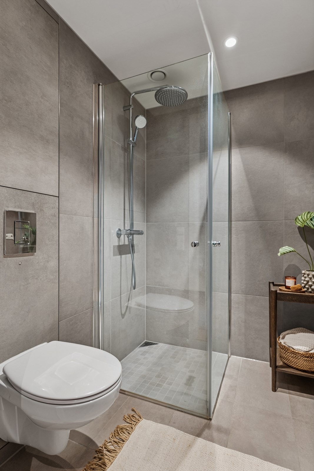 Innredningen har heldekkende servant på skuffeseksjon, speilskap, dusj med innfellbare dusjdører og vegghengt toalett. Galleribilde