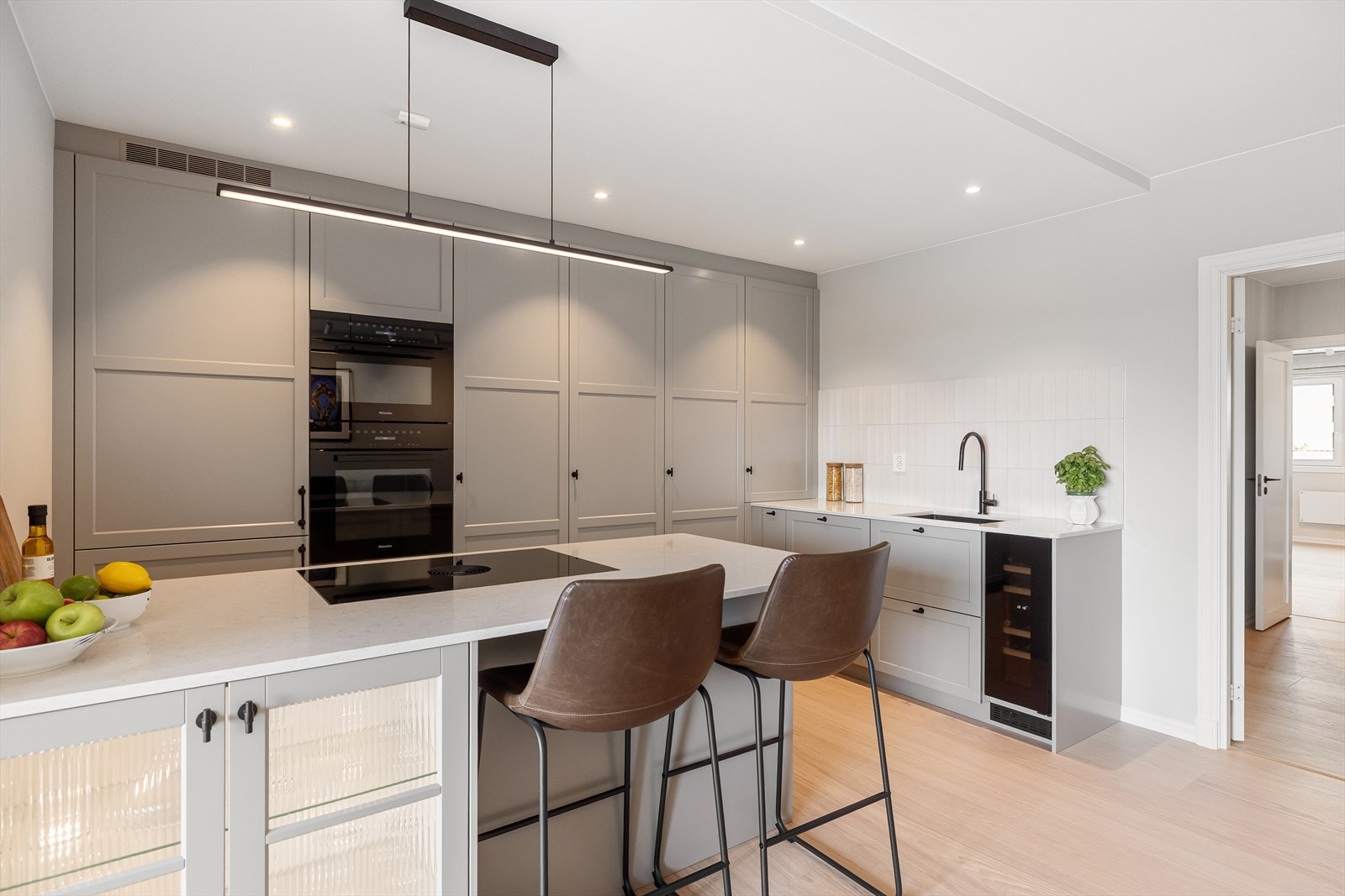 Klassisk innredning fra 2024 med profilerte fronter, enkelte glassfronter og benkeplate i stein. Galleribilde