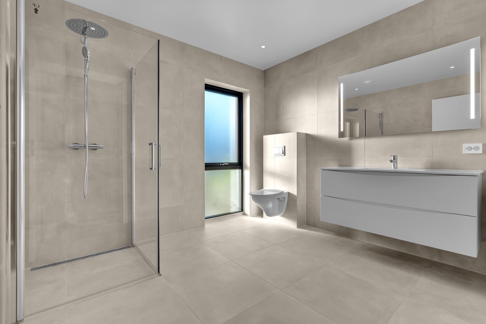 Lekkert og romslig baderom bestående av baderomsinnredning, toalett og dusjhjørne. Galleribilde