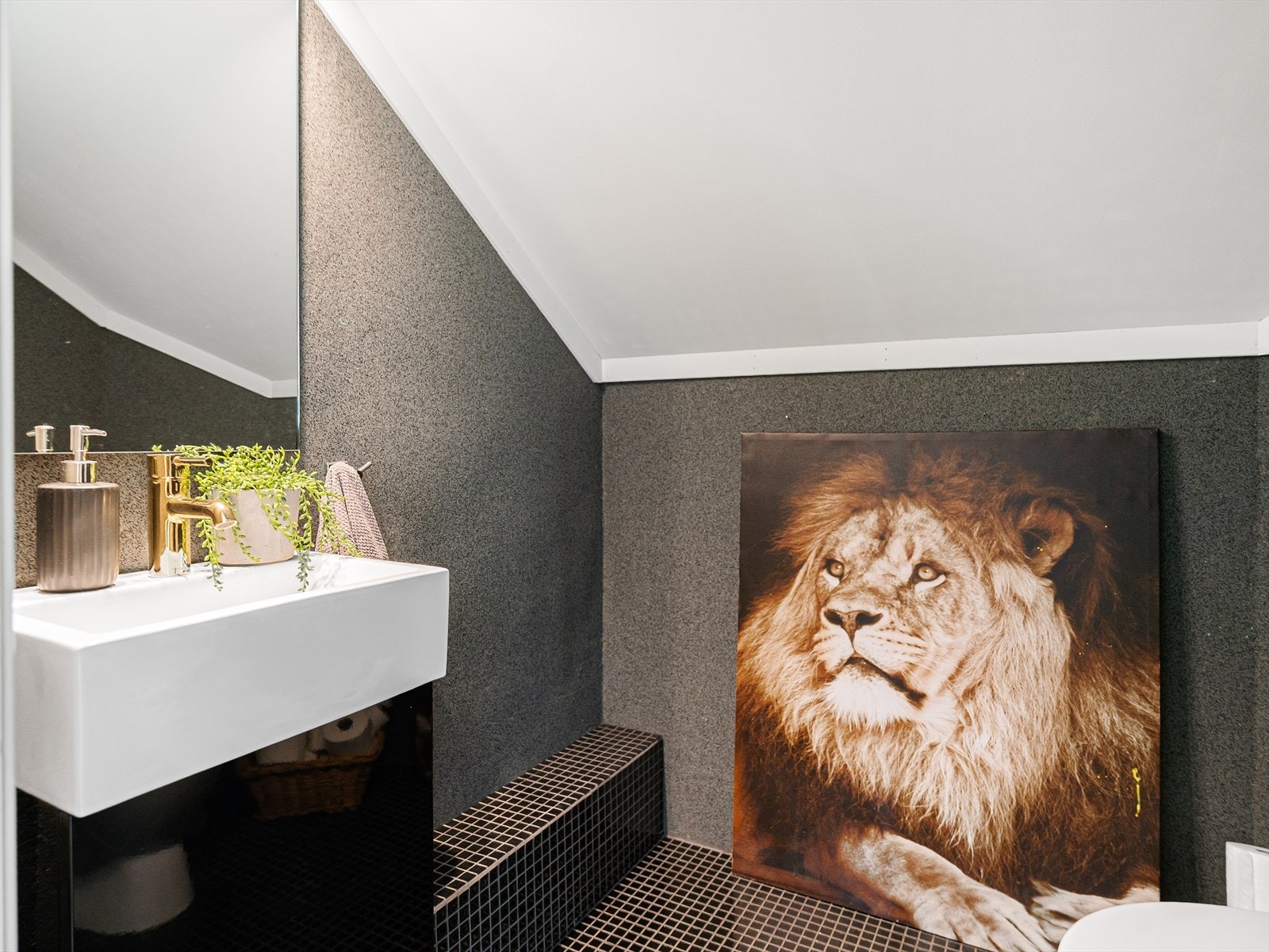 Vegg i vegg er separat toalett pusset opp med mosaikkfliser på gulv og tapet på vegger. Galleribilde