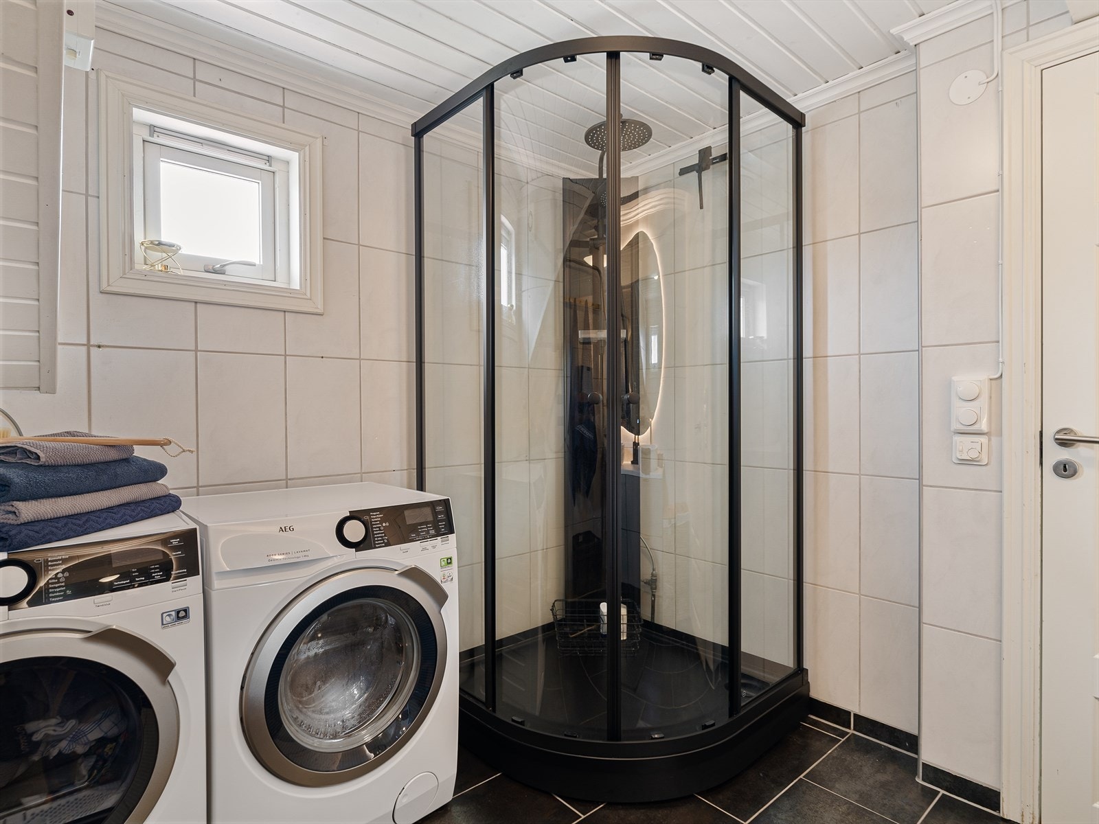 Badet er innredet med servant med innredning, dusjkabinett og opplegg til vaskemaskin. Galleribilde