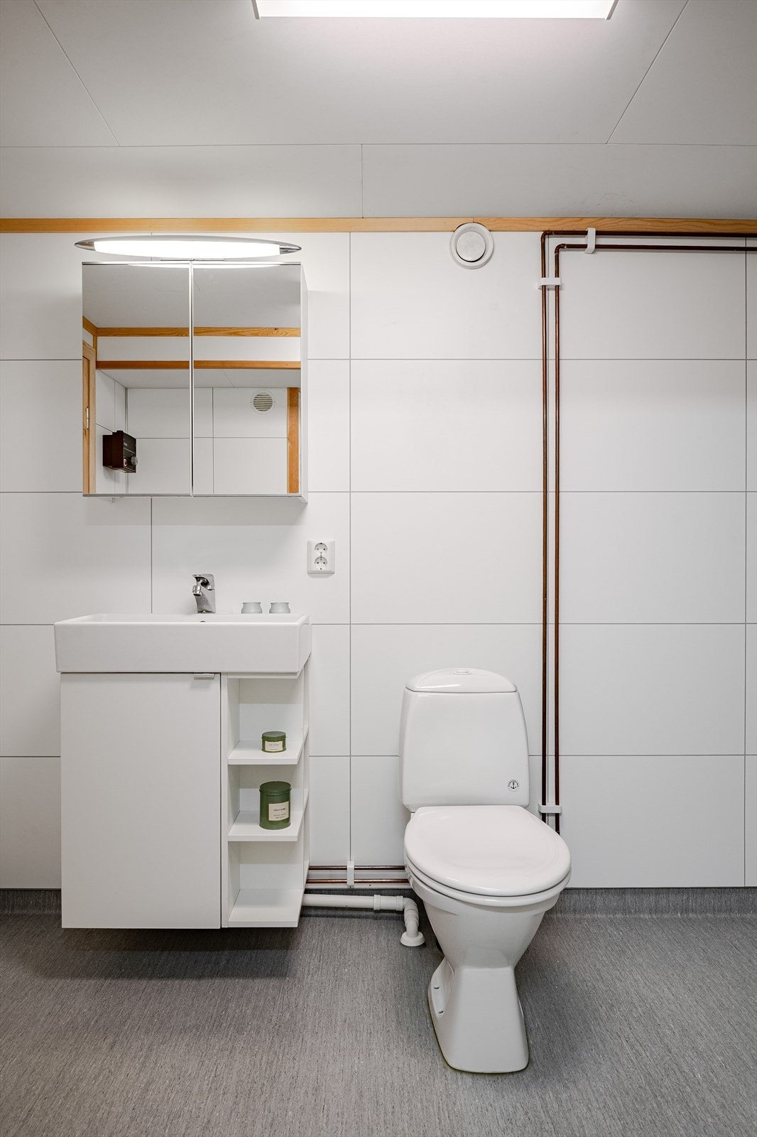 Baderommet er utstyrt med servantskap, speilskap med belysning over, dusjhjørne med glassdører og regnfallsdusj, gulvstående toalett og utslagskum. Galleribilde