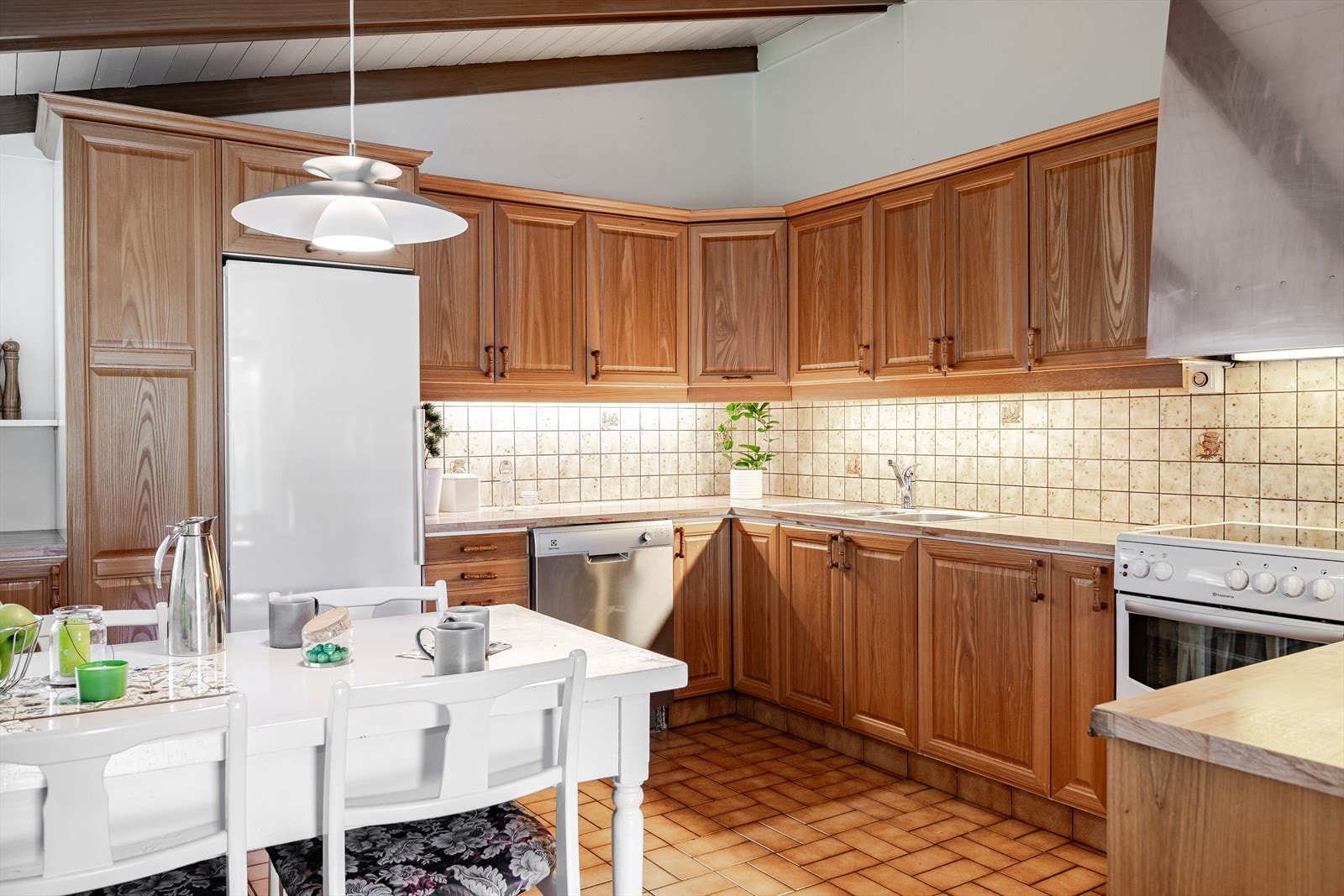 Innredningen har profilerte fronter og laminert benkeplate med nedfelt oppvaskkum. Praktisk med fliser i benkeryggen og belysning under overskapene. Galleribilde