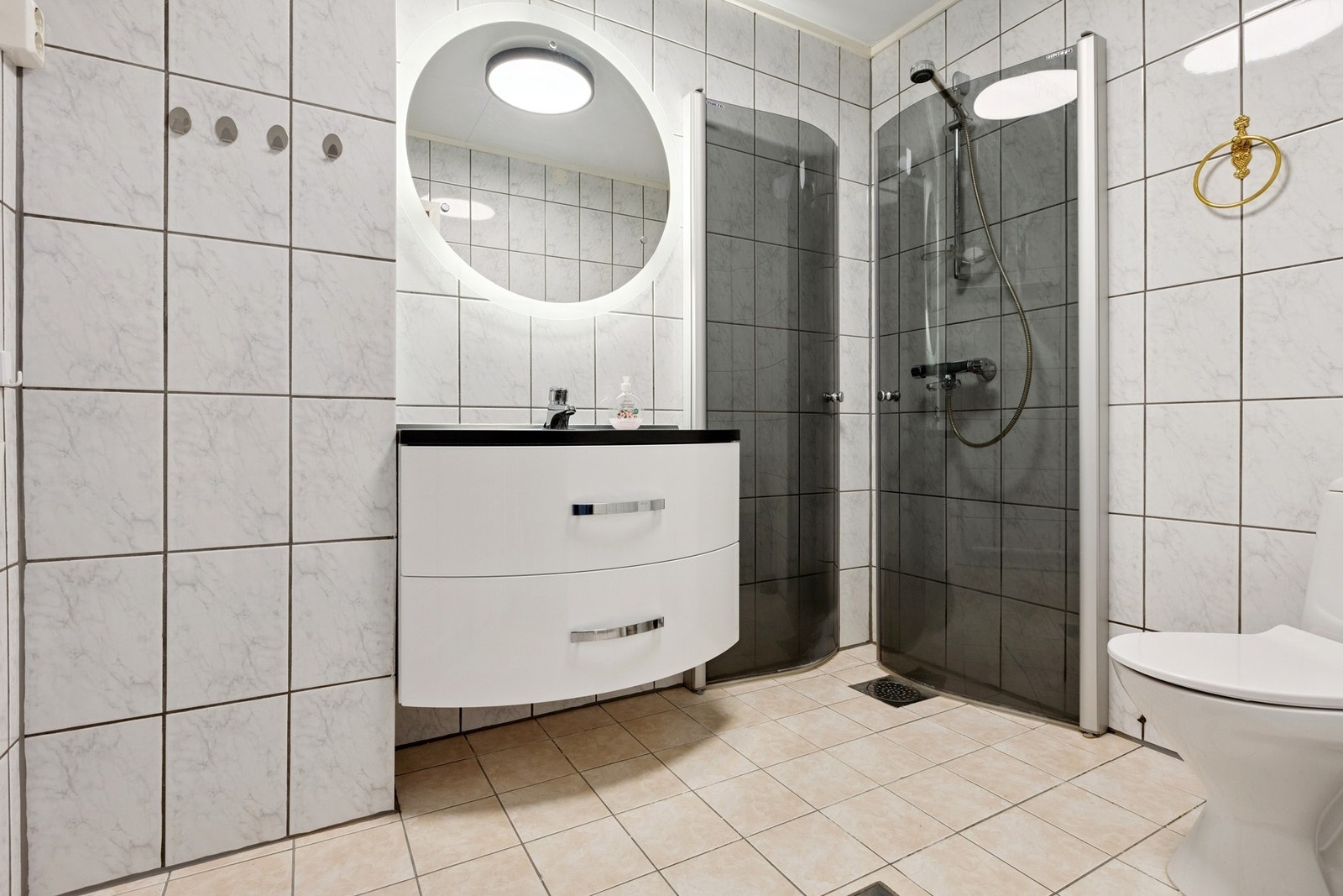 Velkommen til Eineberggata 21 presentert av eiendomsmegler Eirik Jakobsen. Bad med fliser på gulv og vegg. Moderne innredning og dusjnisje med sammenleggbare dusjvegger. Foto: EFKT. Galleribilde