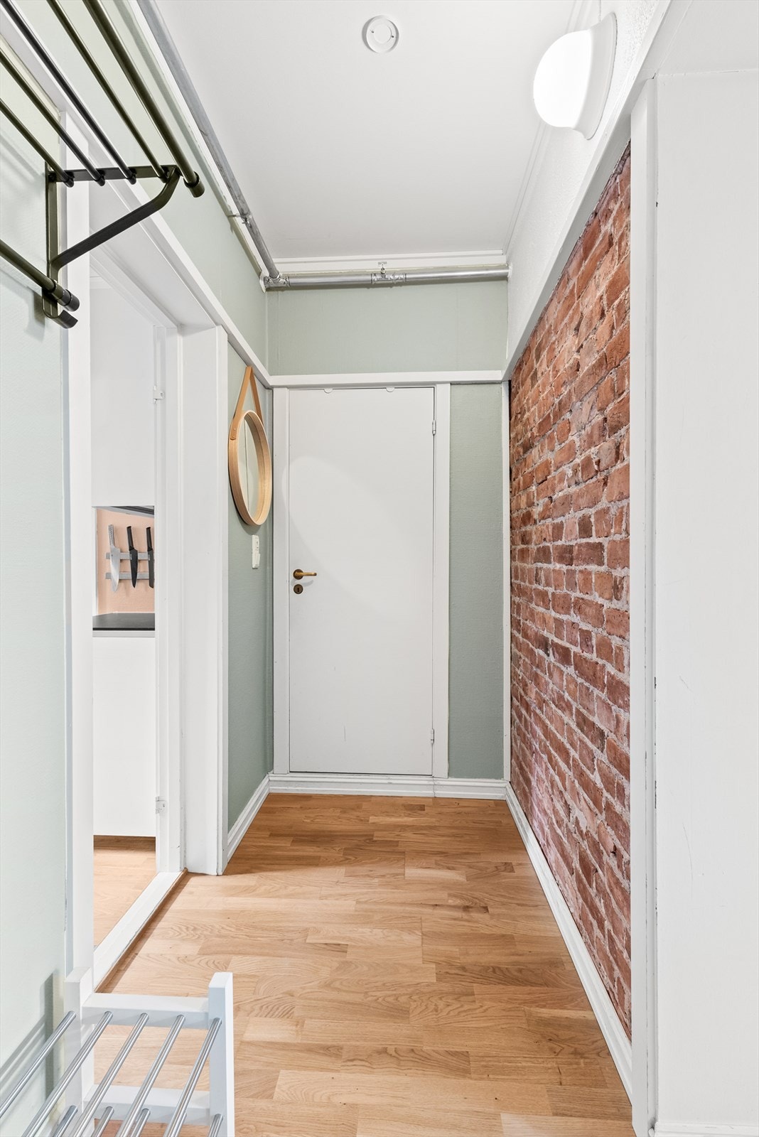 Boligen ønsker deg velkommen med en lys og innbydende entré, hvor en synlig teglsteinsvegg gir et rustikt preg på boligen. Galleribilde