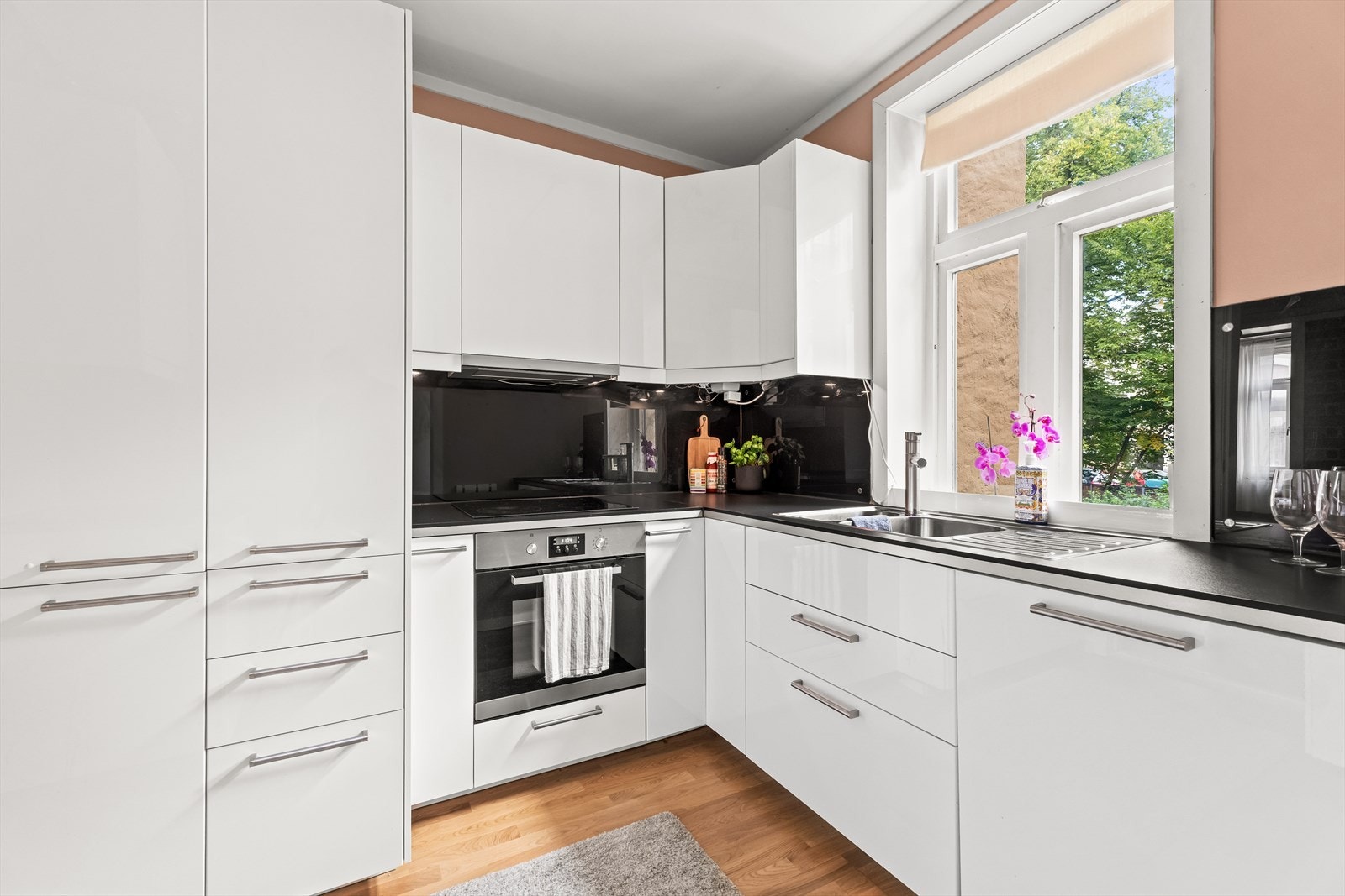 Gode arbeidsflater, glatte fronter og glassplater over benk gir et moderne og praktisk uttrykk. Rolig utsyn mot bakgård. Galleribilde