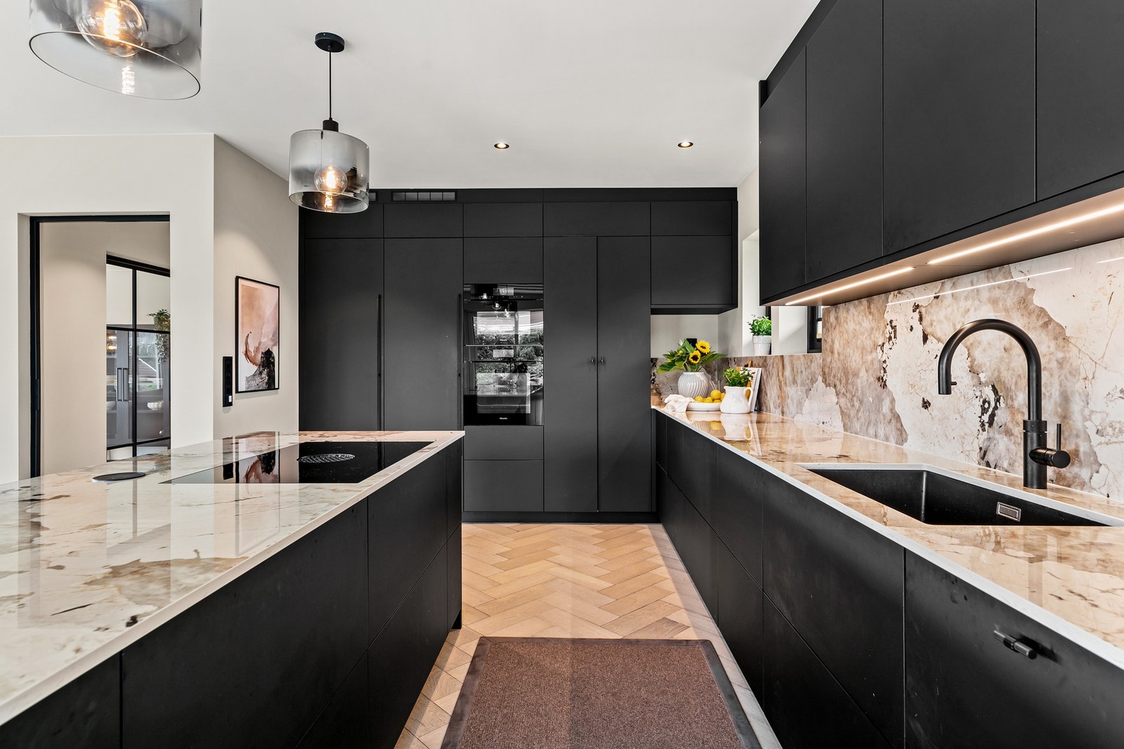 Her er stilrene matte fronter i sort Fenix, supplert med Dekton benkeplate i fargen Khalo med nedfelt kum av kompositt Galleribilde