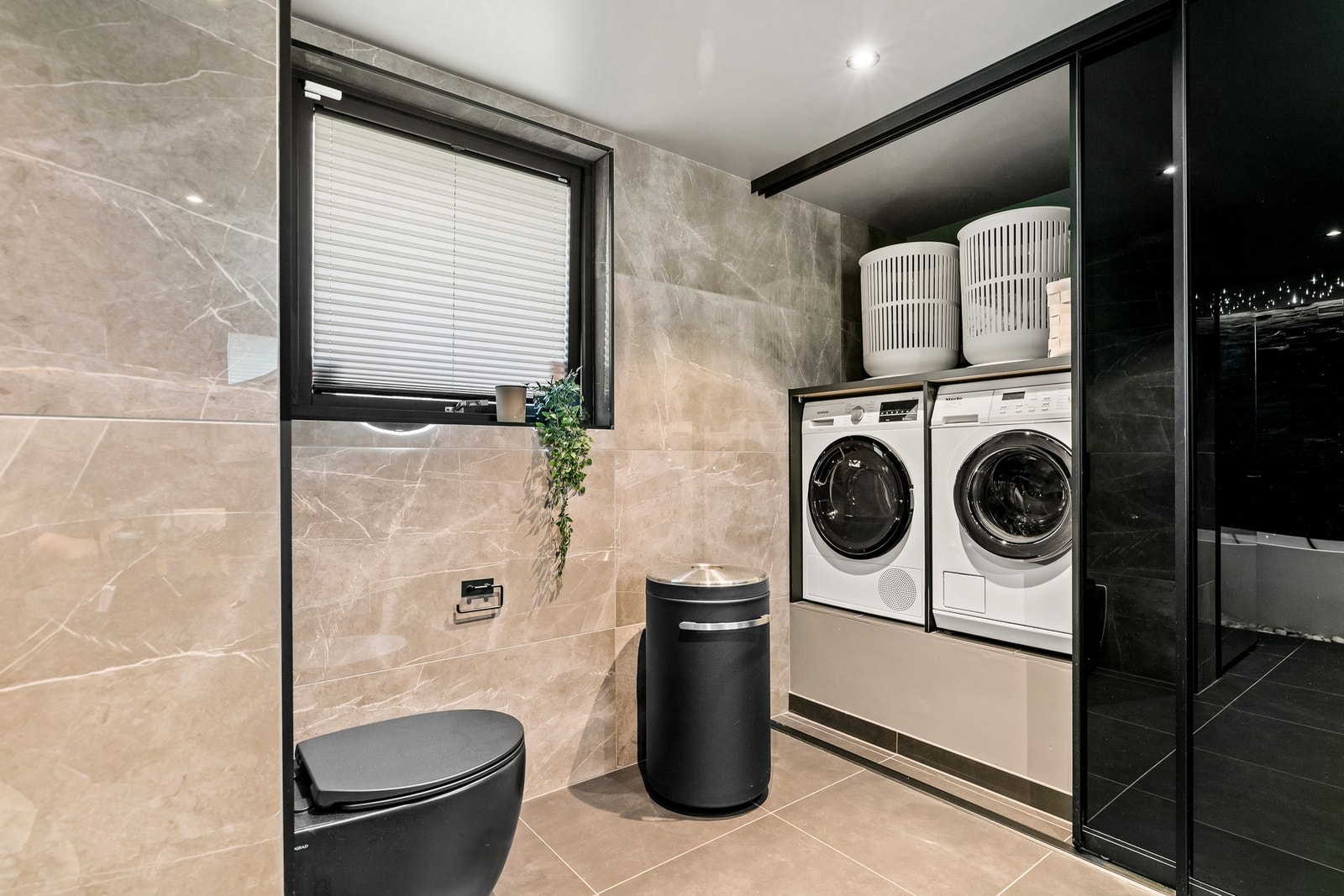 Her er opplegg for vaskemaskin og tørketrommel, med skyvedør foran vaskenisje Galleribilde