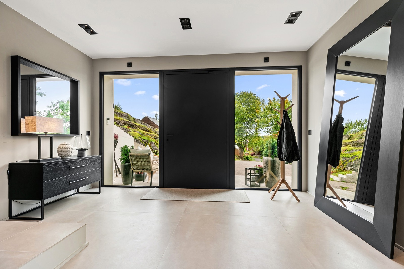 Det lekre inngangspartiet har ytterdør fra sveitsiske Schüco, m/pivothengsler og takhøye sidefelt i glass på begge sider Galleribilde