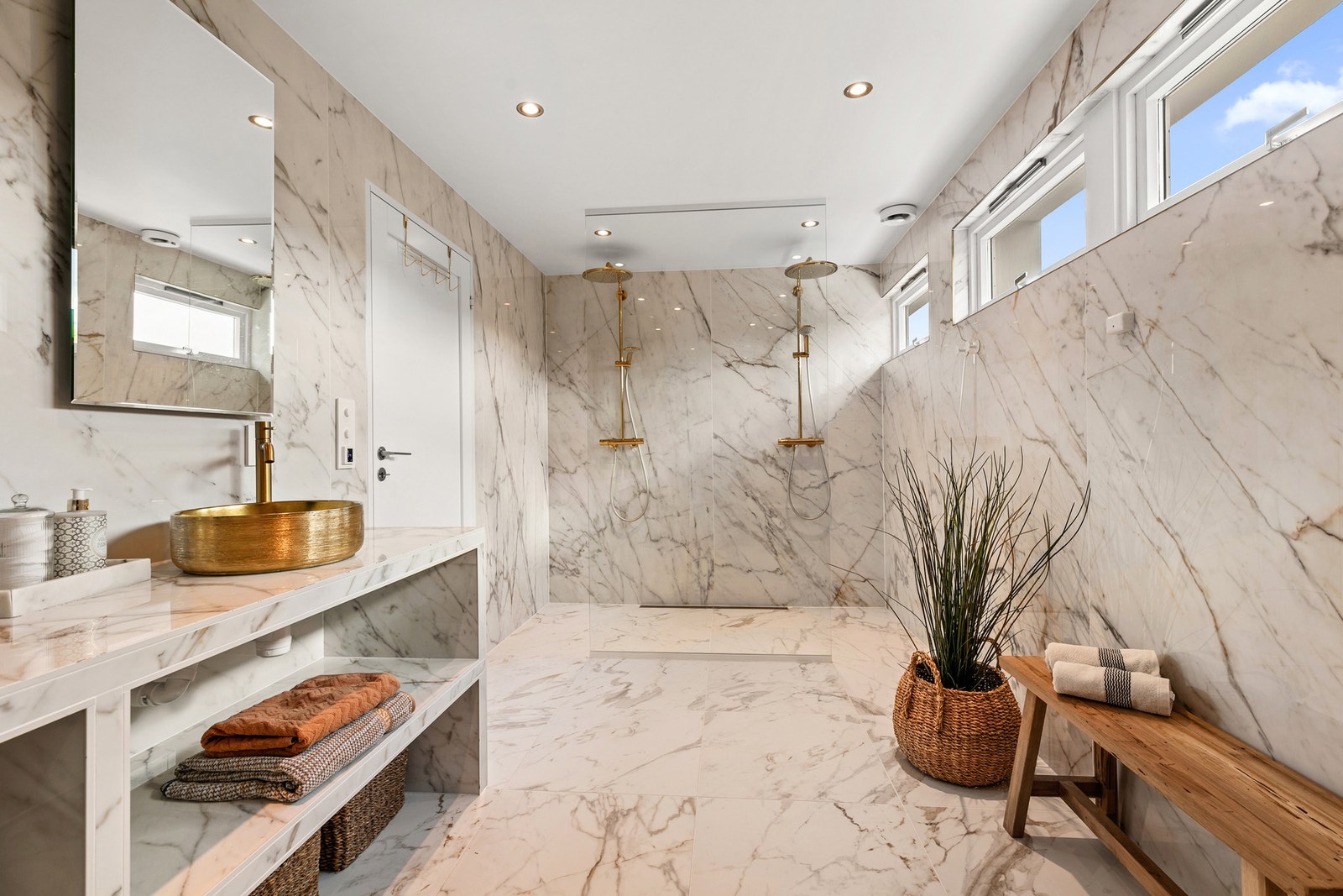 En delikat dusjsone med 2 dusjer har slukrenne, og takhøy glassvegg som sprutskjerm mot innredning Galleribilde