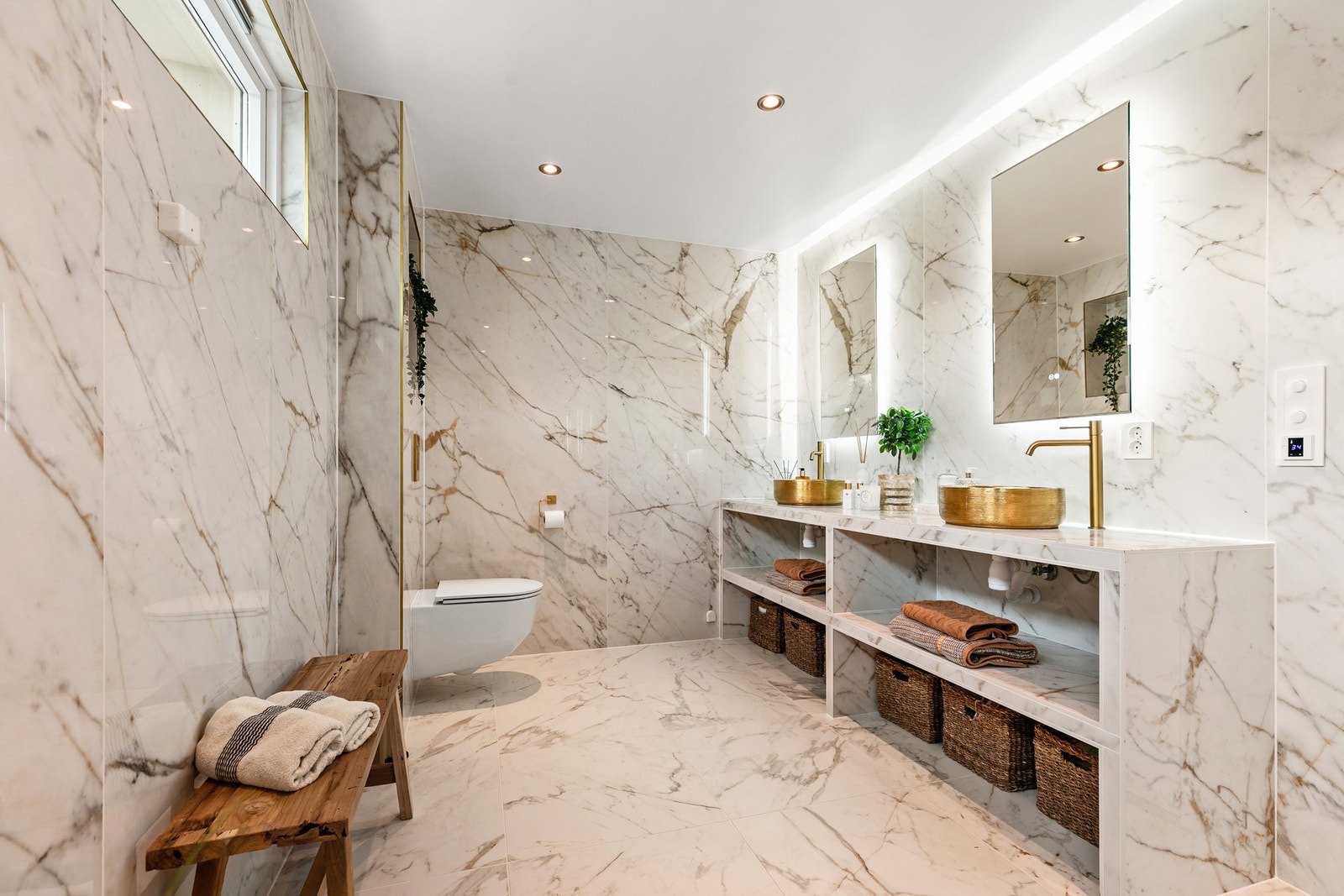 Badet har et eksklusivt preg med gullfargede toppmonterte Enzo servantskåler fra Scala Galleribilde