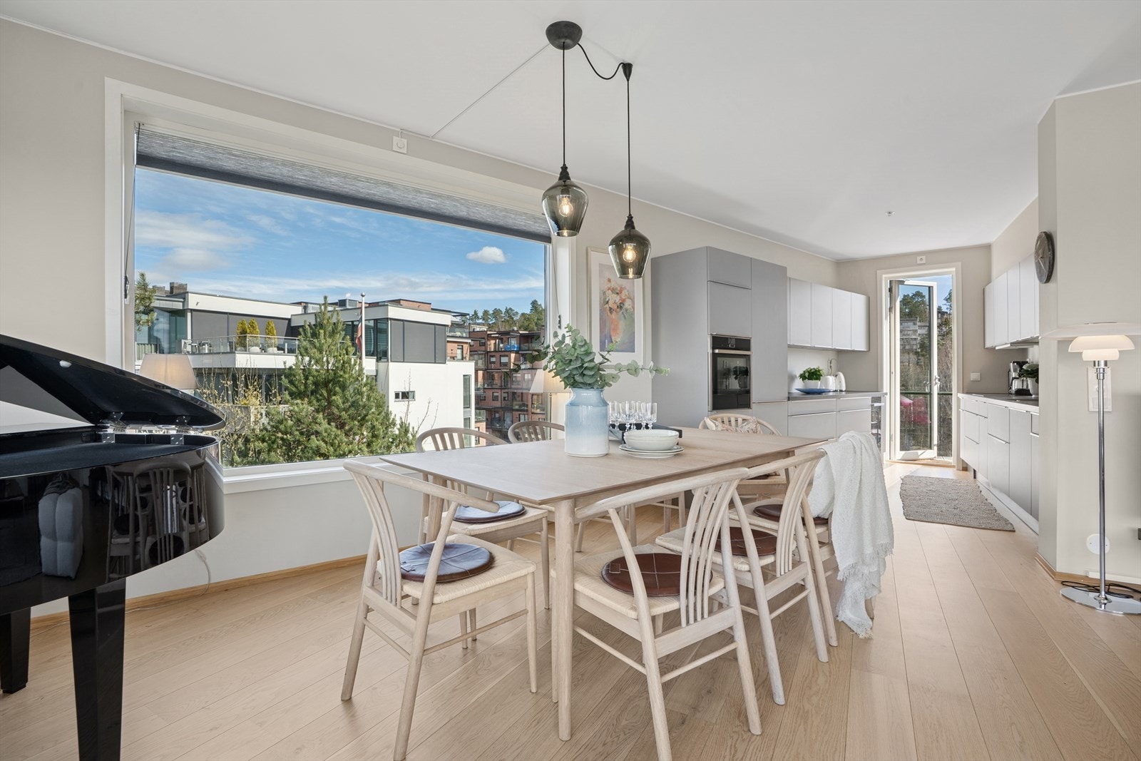 Mellom kjøkken og stue kan man fint innrede med en spisegruppe for en sosial atmosfære. Galleribilde