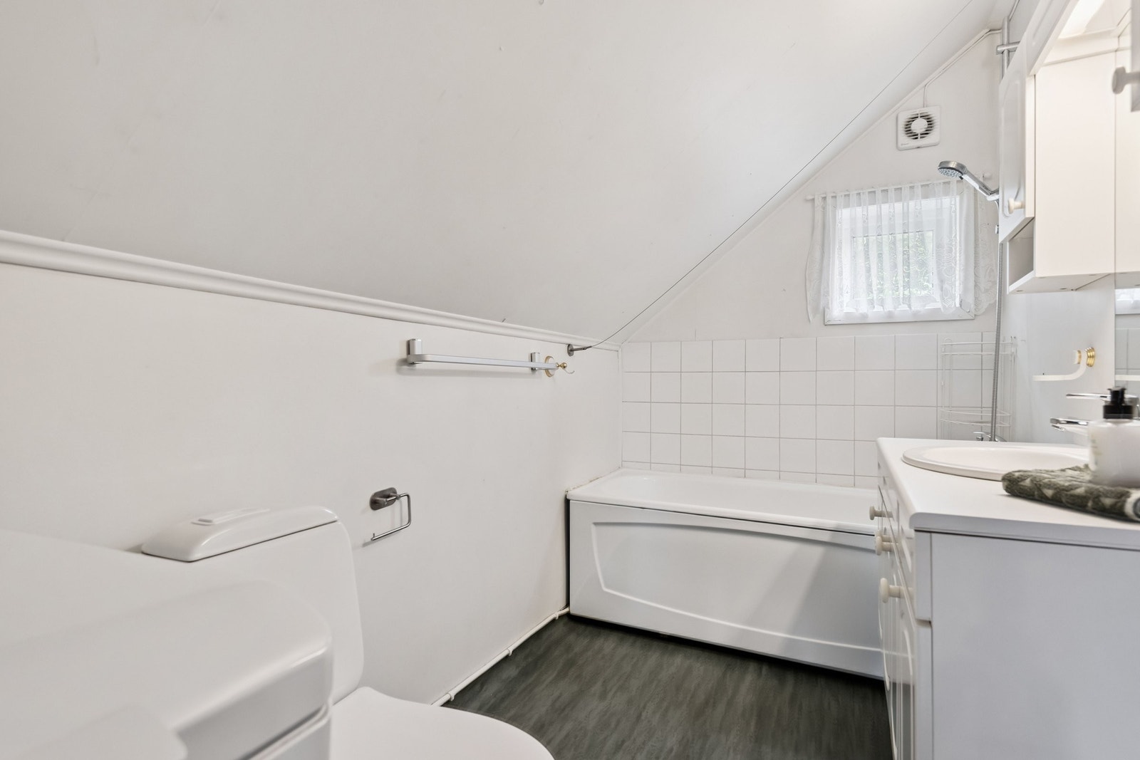 Bad med baderomsinnredning, badekar/dusj, toalett og vaskemaskin. Galleribilde