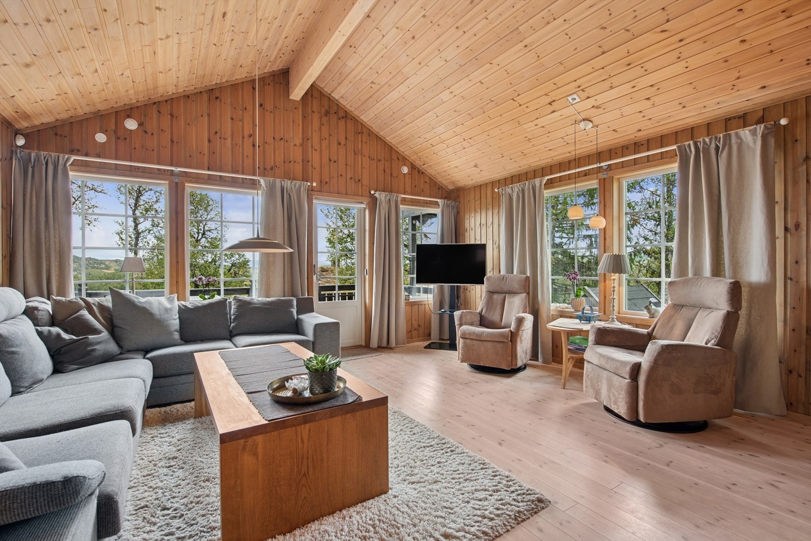 Stuen med mønet tak gir ekstra takhøyde og skaper en lys og innbydende romfølelse. Galleribilde