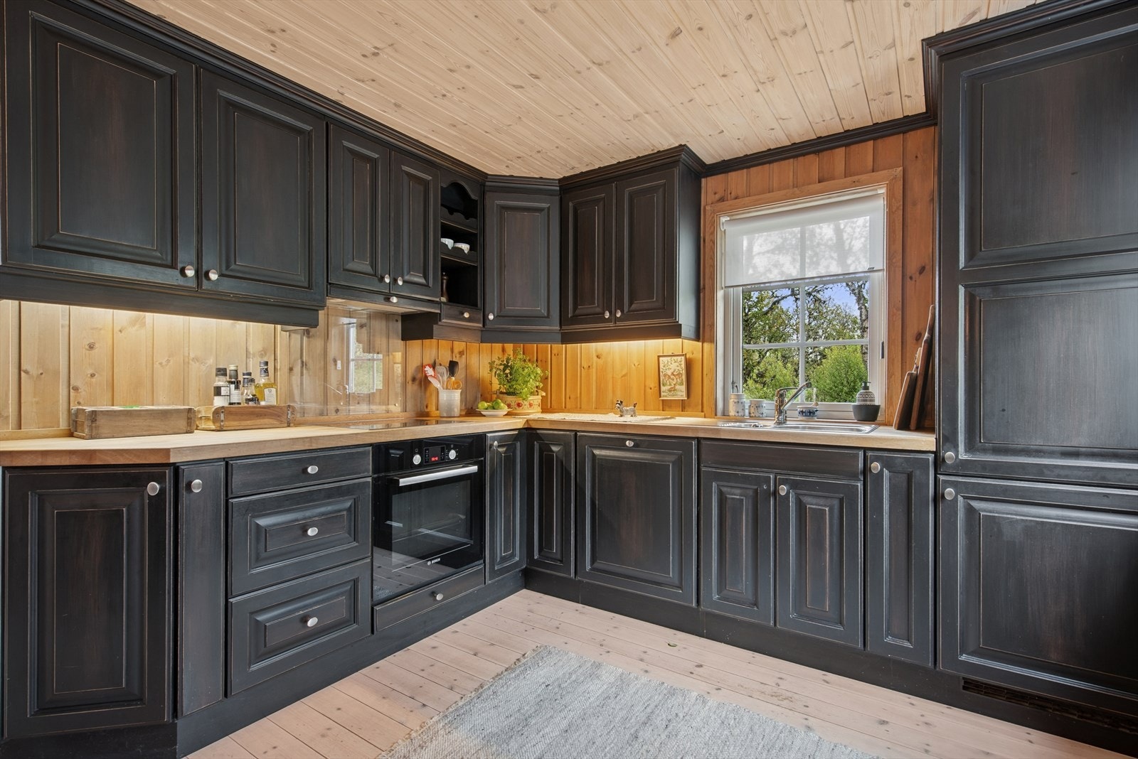 Hytta har et stilfullt og velutstyrt kjøkken i heltre, med benkeplater i eik og sortlaserte, profilerte fronter fra Dalane Trevare - et uttrykk for kvalitet og håndverk. Galleribilde
