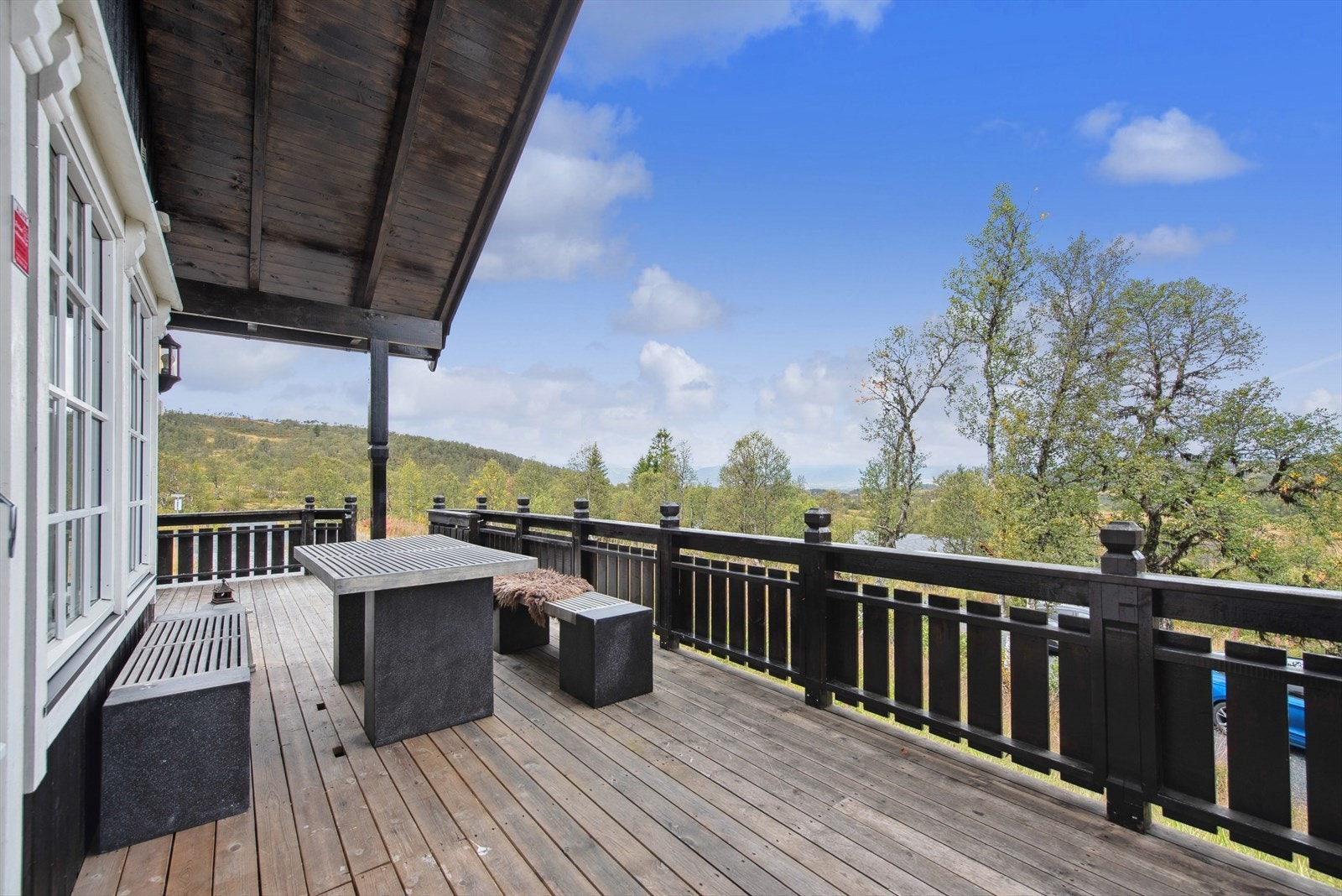 Hytta har flere koselige uteplasser og en romslig veranda. Under benken finner du en smart gulvluke som gjør det enkelt å lagre ved. Galleribilde