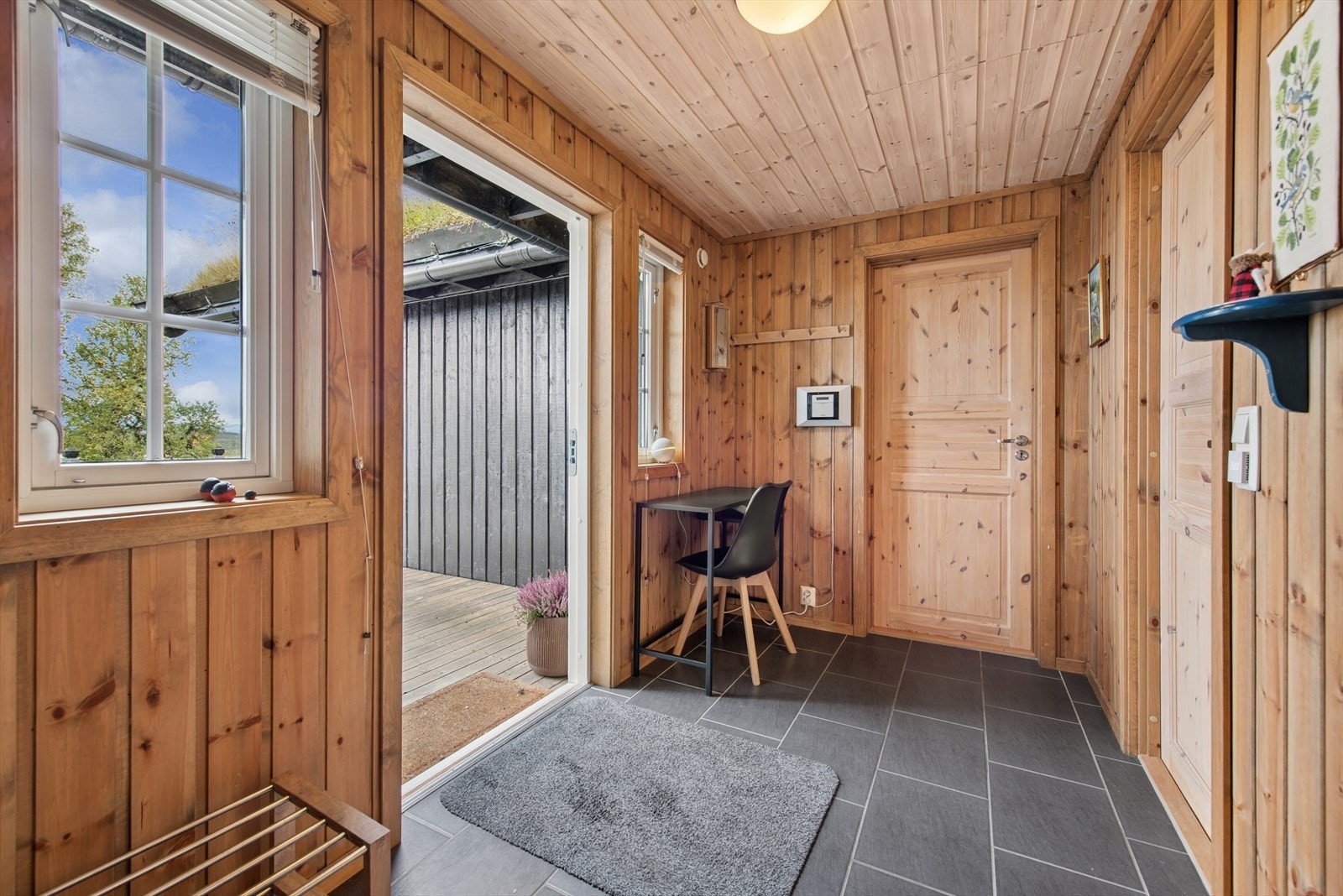 Gangen er romslig med flislagt gulv og varmekabler. Praktisk med inngang til vaskerom direkte fra gangen. Galleribilde