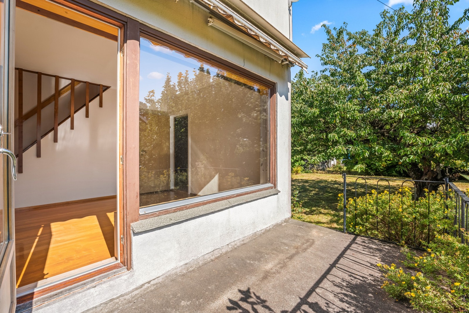 Utgang fra stuen til terrasse med trapp ned til hagen Galleribilde