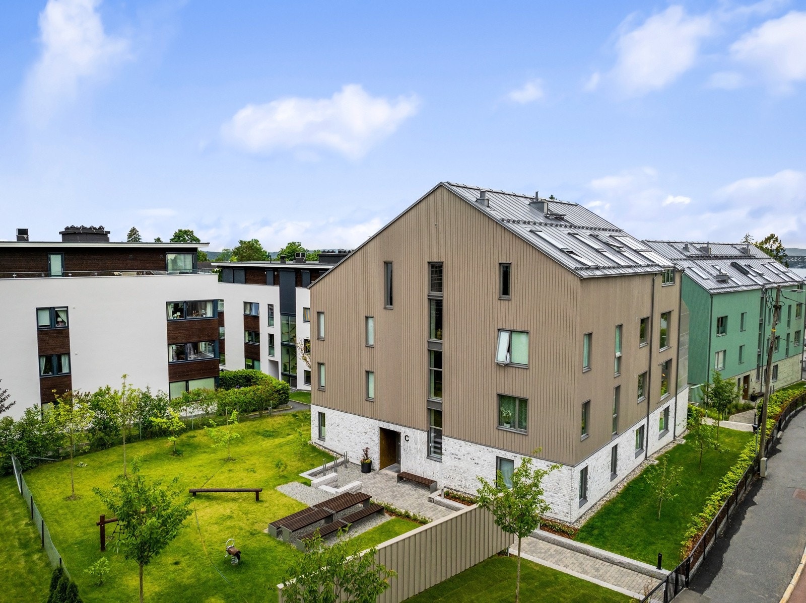 Steinlagte interne gangveier og parkeringsarealer, gjerder og port rundt eiendommen. Galleribilde