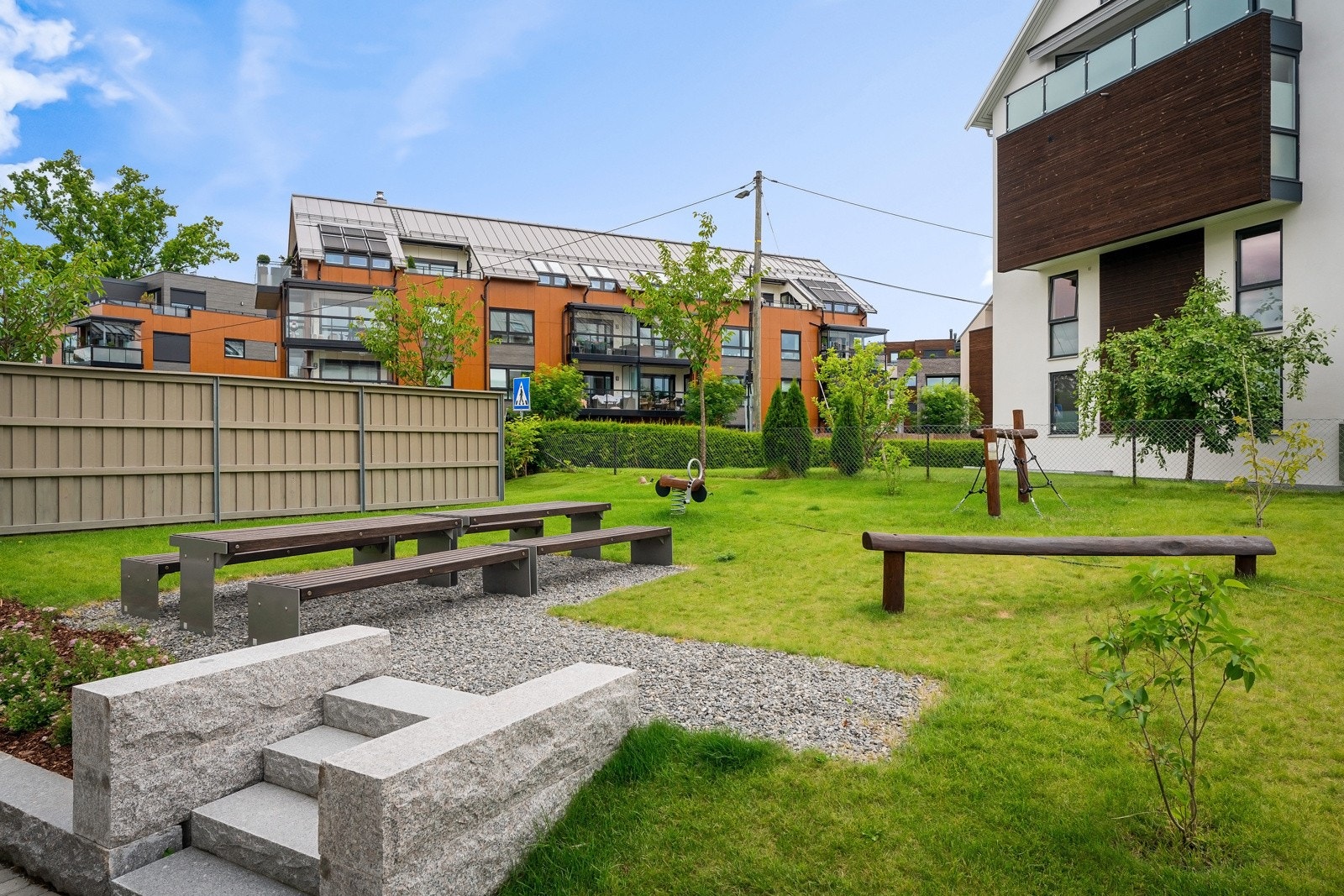 Tomten er opparbeidet med beplantning, plen områder for lek og opphold. Galleribilde