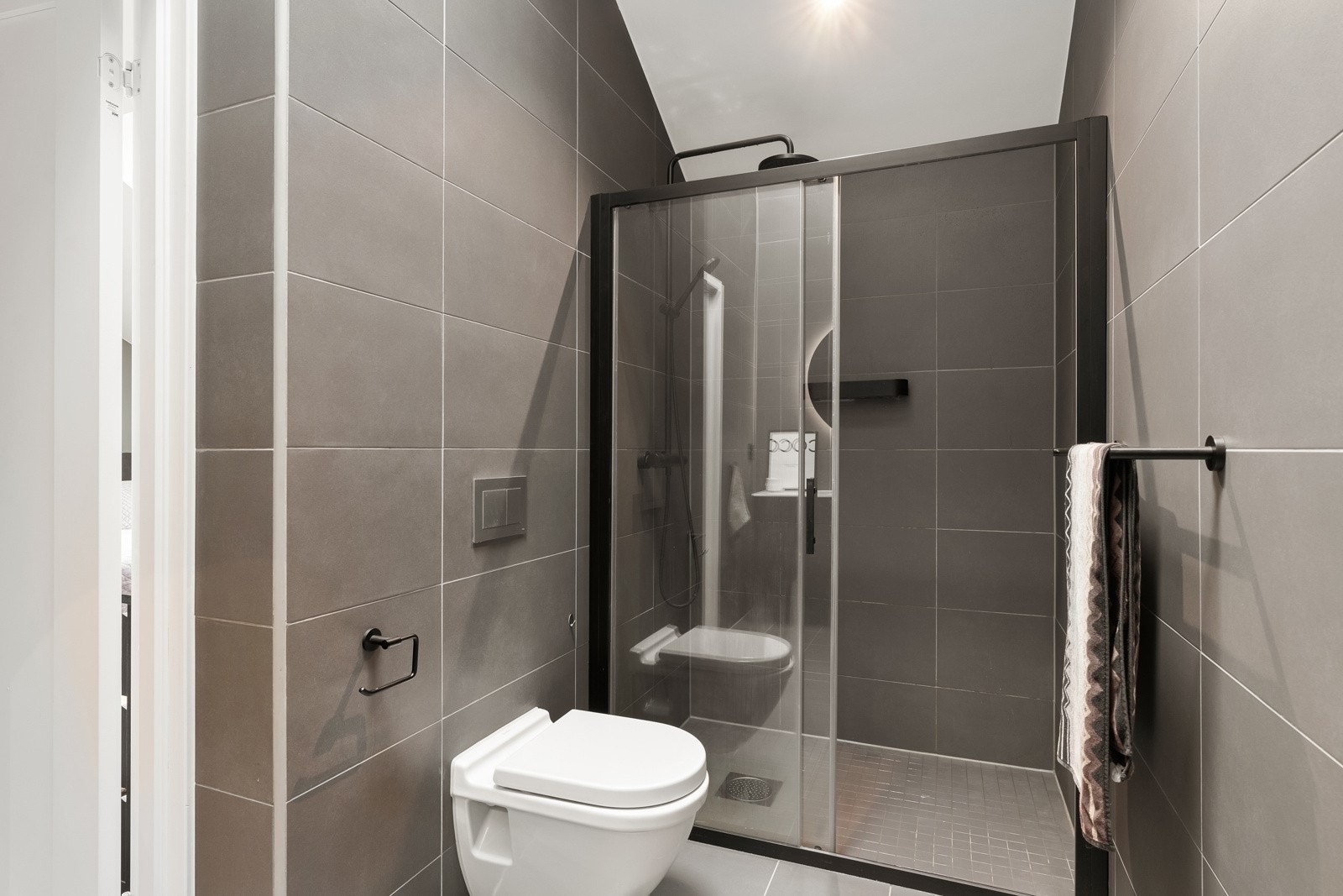 Gulvflatene er flislagte, med varmekabler og nedsenk i dusjsonen med mosaikkfliser Galleribilde