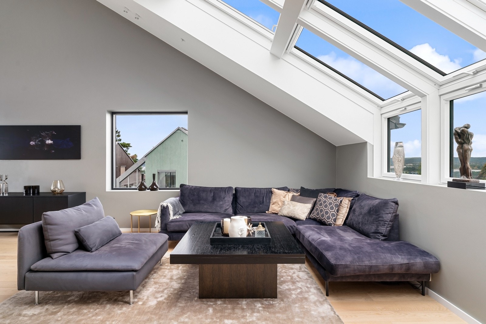 Moderne, svarte detaljer på stikkontakter, lysbrytere, karmer, mm. gir stuen et elegant preg og utgjør en lekker kontrast mot den ellers lyse og luftige estetikken Galleribilde