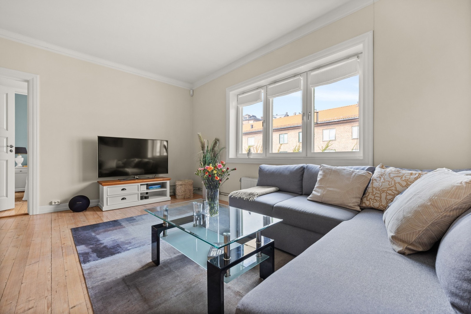 Leiligheten har en stor og lys stue med god plass til sofa, TV og tilhørende møblement Galleribilde