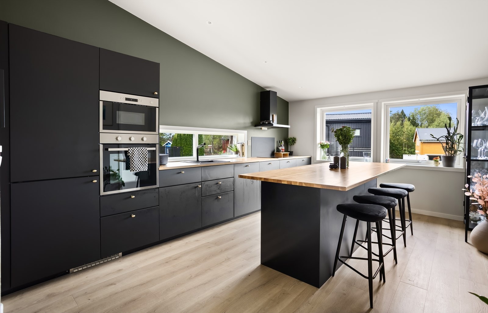 Den praktiske kjøkkenøya med sitteplasser fungerer som et naturlig samlingspunkt i rommet. Galleribilde