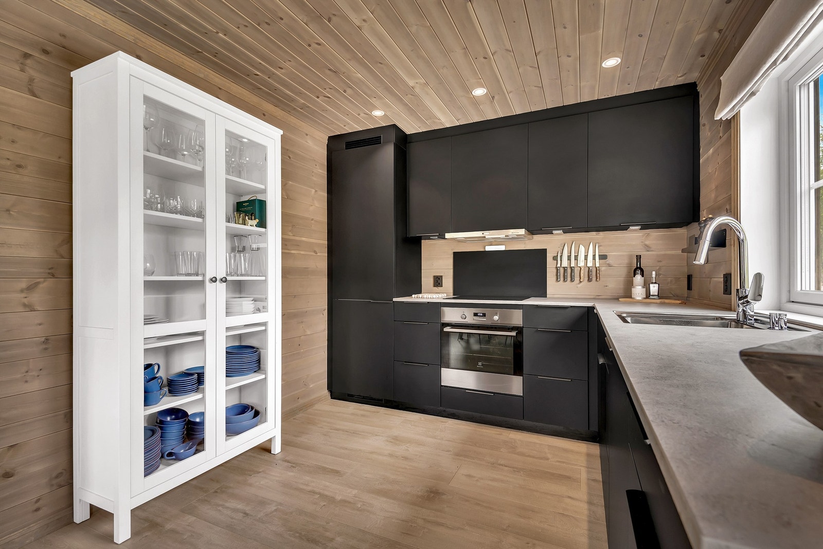 Stilig kjøkkeninnredning fra Kvik med sorte slette fronter og takhøye overskap. Laminat benkeplate med underlimt oppvaskkum. Galleribilde