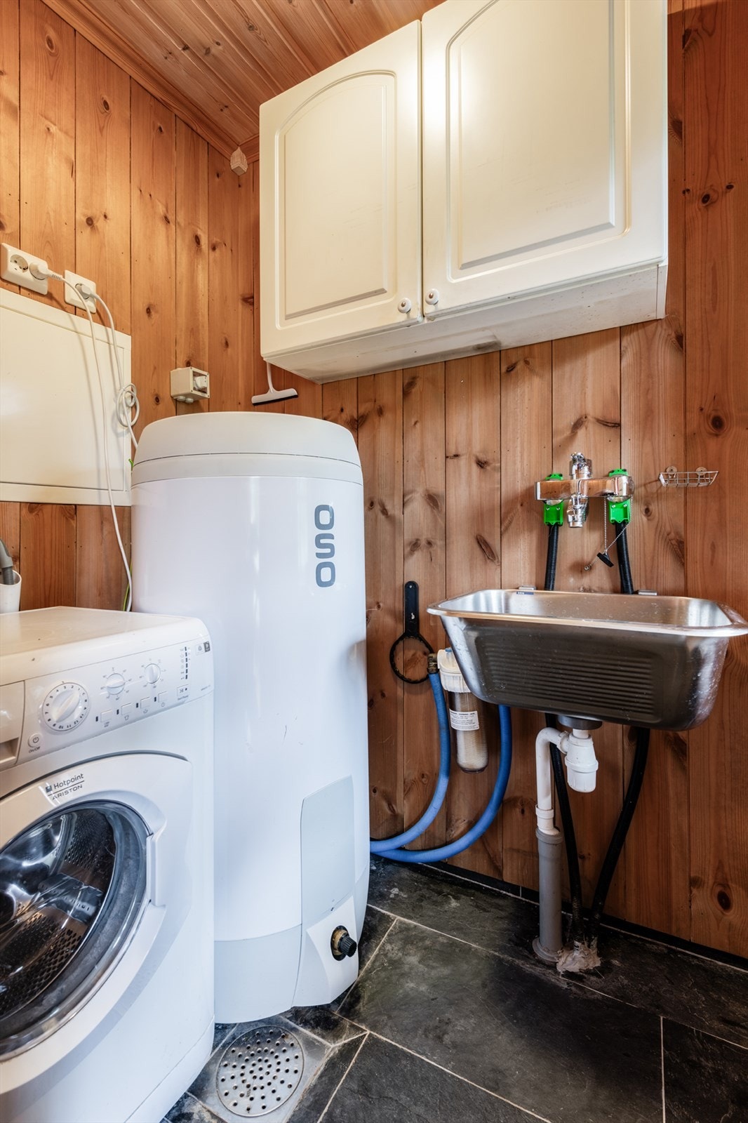 Praktisk vaskerom/tekniskrom med varmtvannsbereder, vaskemaskin og skyllekar. Beliggende rett ved inngangen. Galleribilde