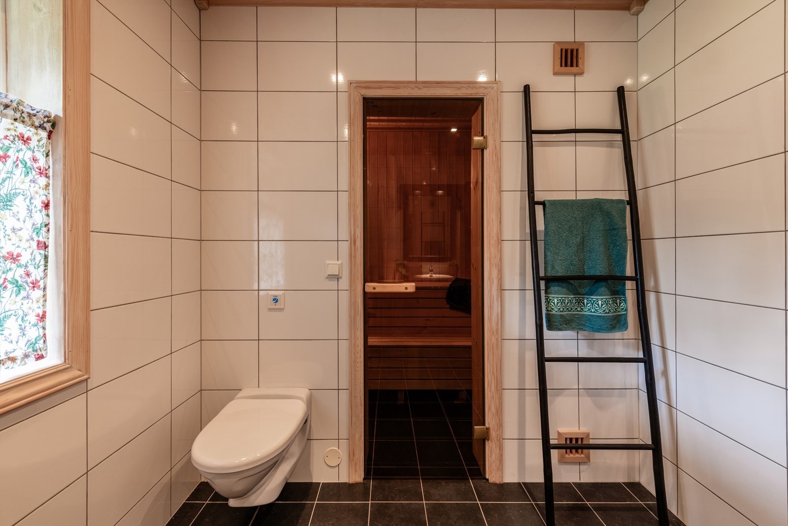 Bad med tilknyttet badstue. Flislagte overflater og moderne fasiliteter gir en behagelig opplevelse. Perfekt for avslapning og velvære. Galleribilde