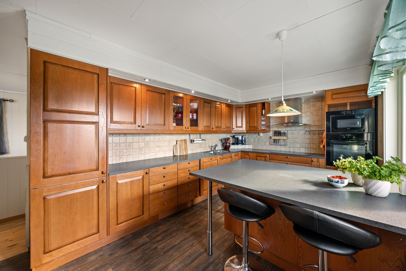 Kjøkkenet har en praktisk utforming som gir mye skap- og benkeplass, samt kjøkkenøyen som er et sosialt samlingspunkt. Galleribilde