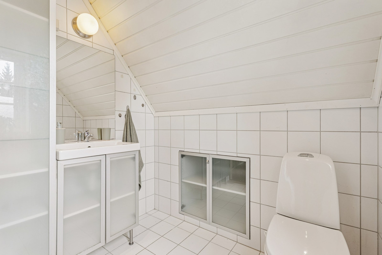 Flislagt bad i loftsetasjen, innredet med servant og toalett Galleribilde