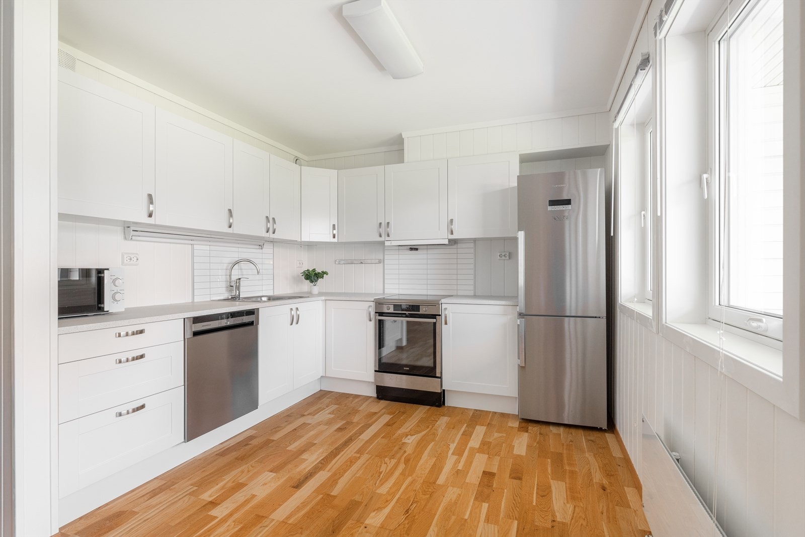 Tidløst kjøkken med hvit innredning med glatte fronter, og laminert benkeplate. Det er meget godt med skapplass og god arbeidsflate på benken. Galleribilde