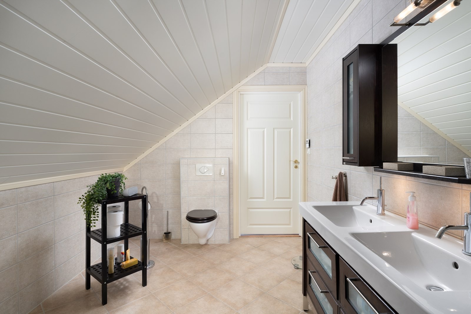 Romslig og moderne baderom i 2. etasje med skråtak og stilrent design. Galleribilde