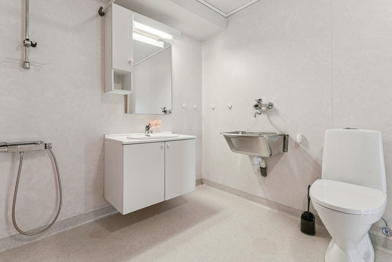 Baderom frå byggeår med golvbelegg og baderomsplater på vegg. Galleribilde