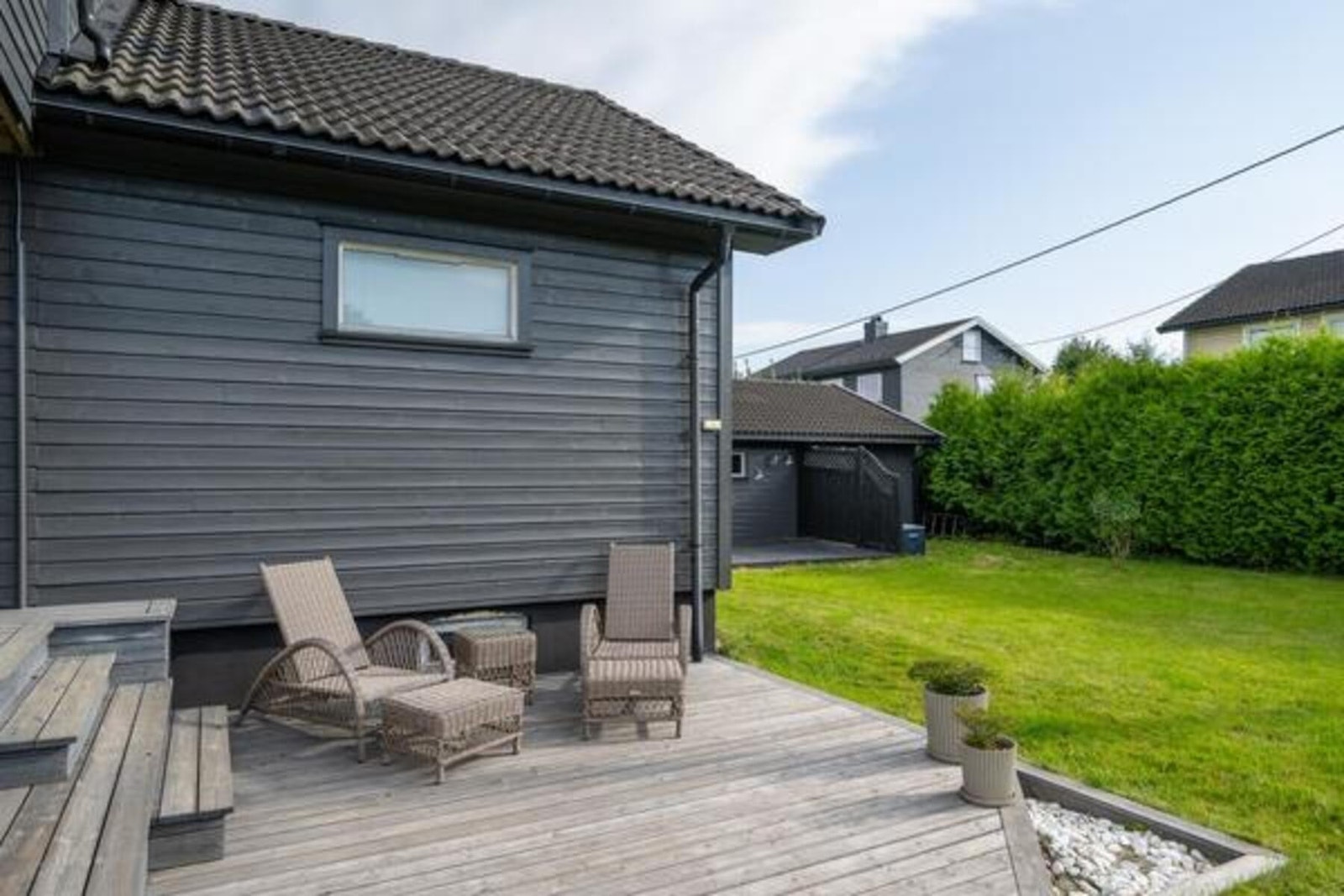 Det er terrasse både ved tilbygget og i tilknytning til garasjen Galleribilde