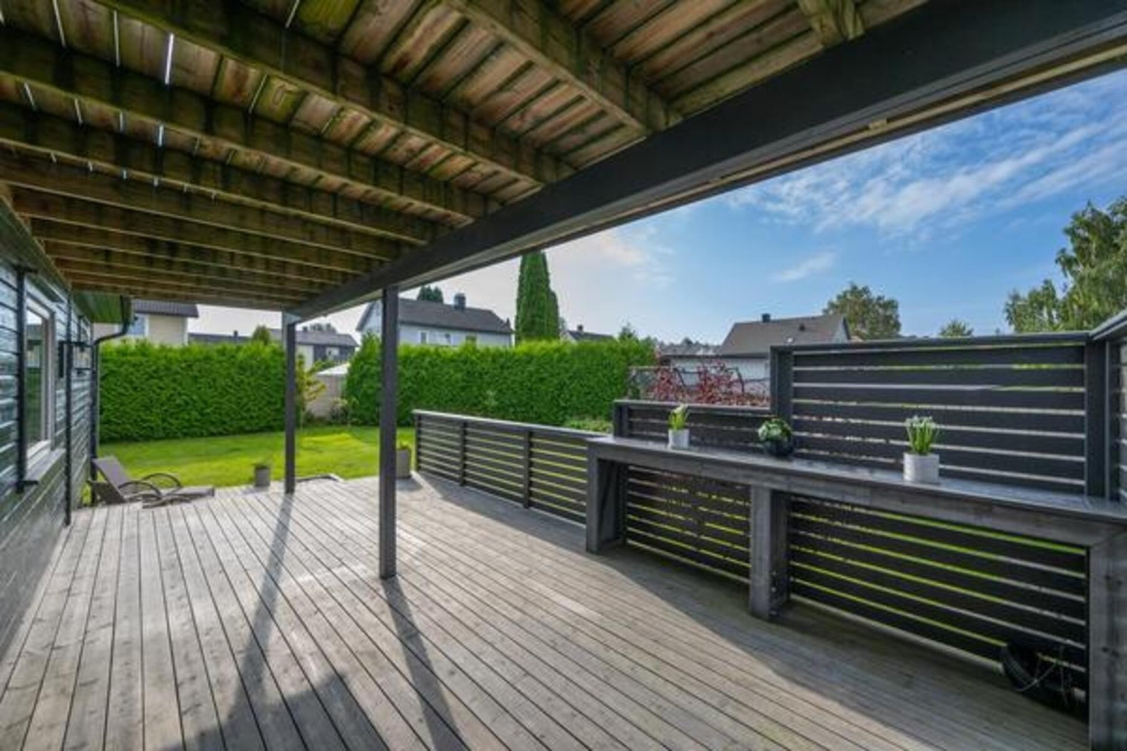 Det er flere store uteplasser - her ser vi litt av den overbygde terrassen i 1. etasje Galleribilde