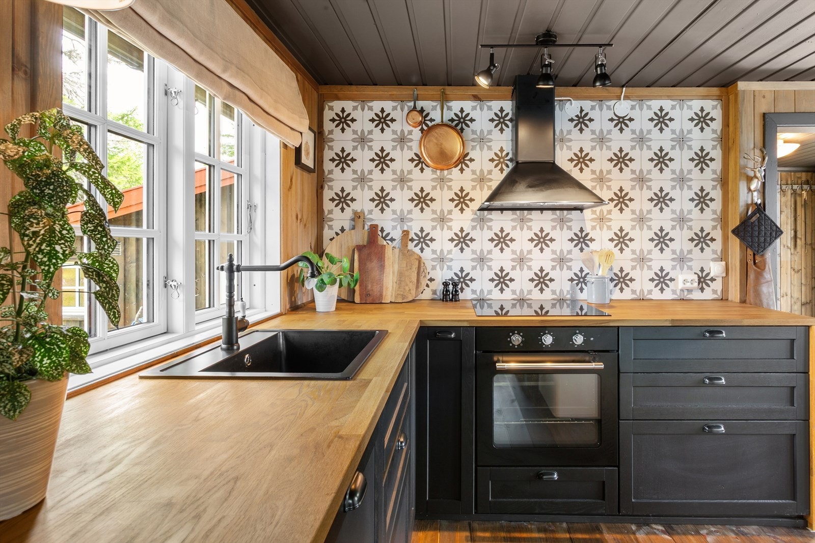 Moderne og elegant kjøkkeninnredning med sorte profilerte fronter og slitesterk benkeplate av heltre. Galleribilde