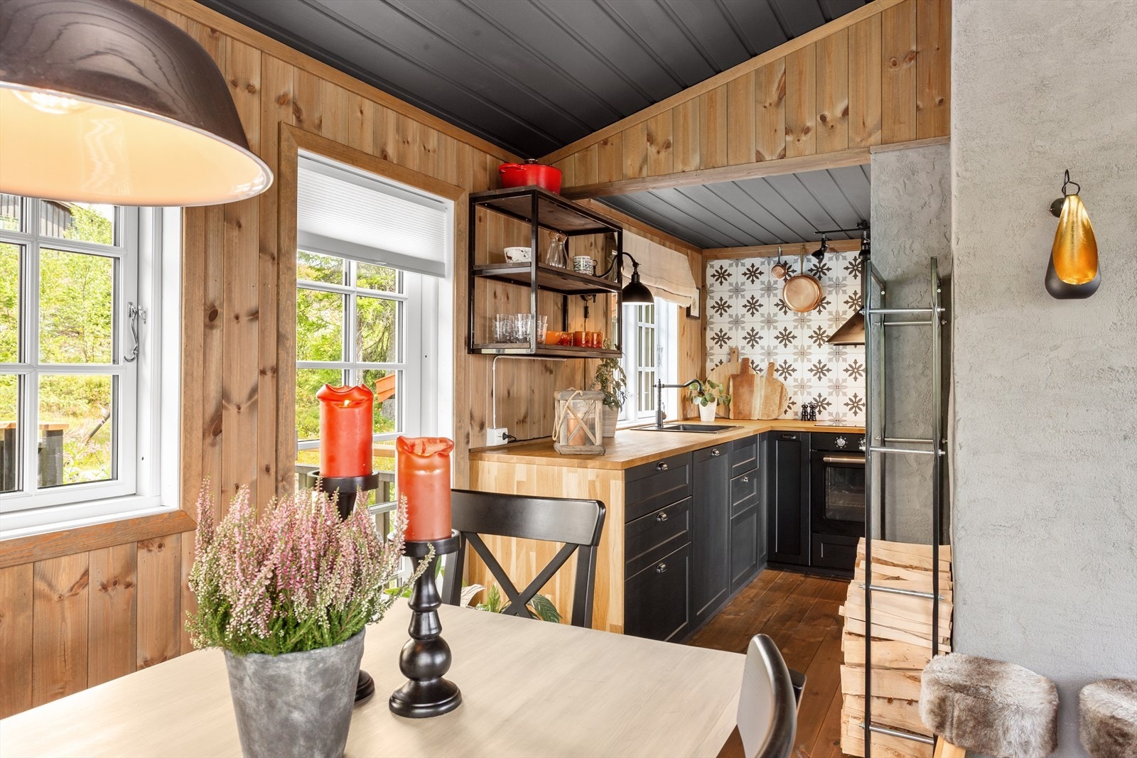 De grove tømmerveggene skaper en varm og autentisk atmosfære, mens store vindusflater slipper inn rikelig med lys og åpner opp mot naturen utenfor. Galleribilde