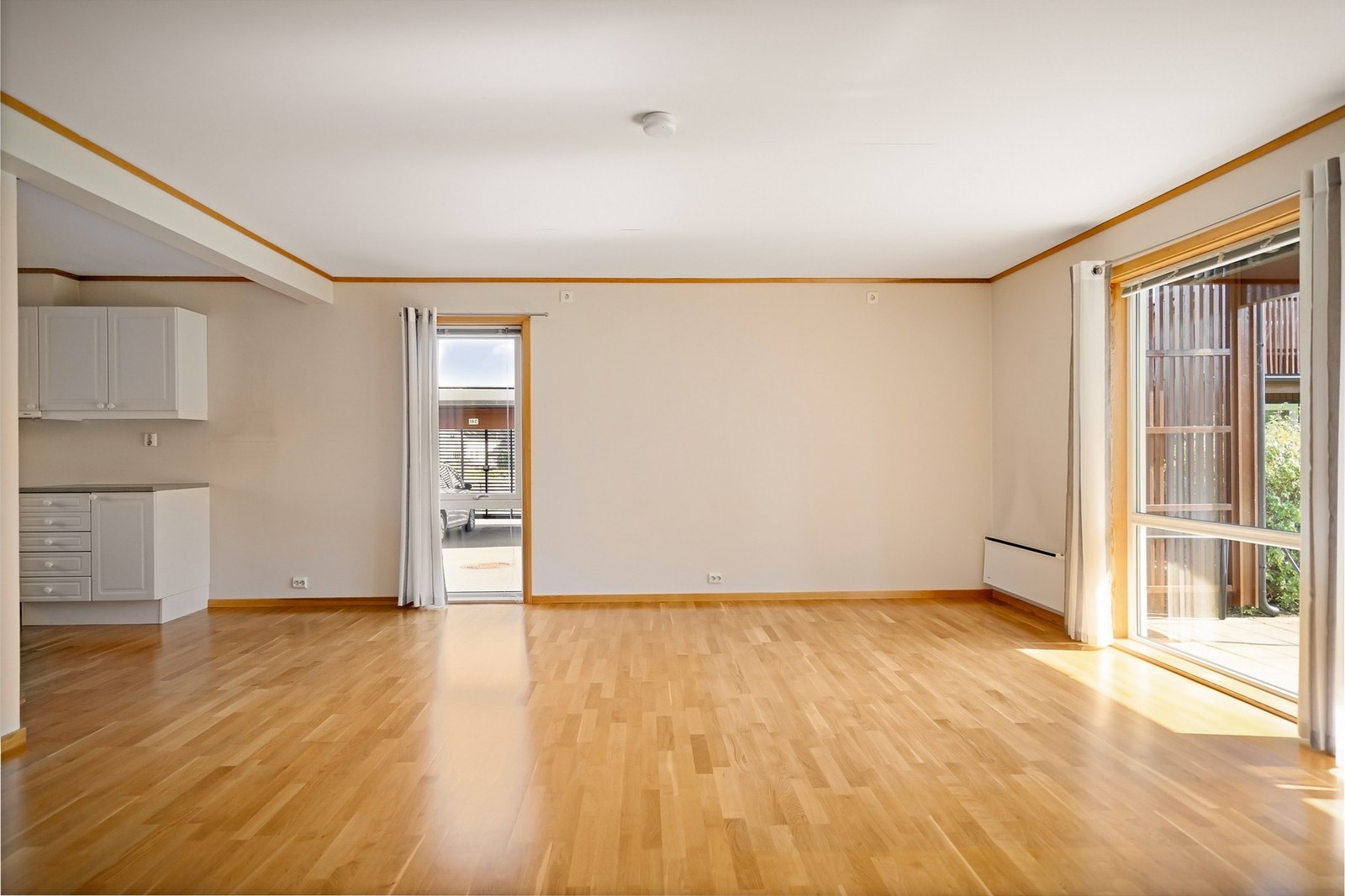 Det er åpen løsning mellom stuen og kjøkkenet. Galleribilde