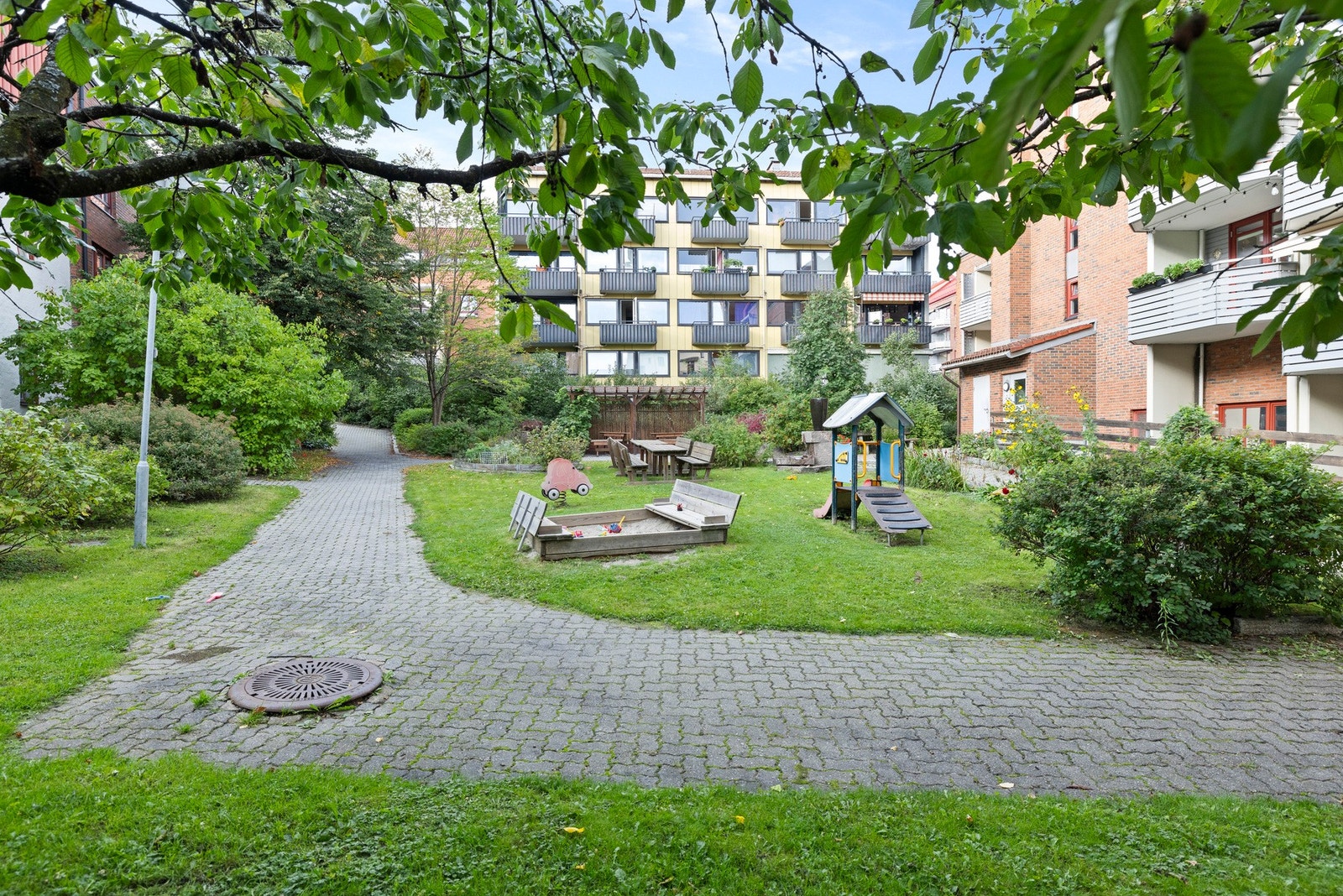 - En prisvinnende og meget pent opparbeidet bakgård med fontene, gangarealer, gressplen, plommetrær, morelltrær, solbærbusker og diverse urter. Her er det også flere sittegrupper, grillmuligheter og egen lekeplass for de minste - Galleribilde