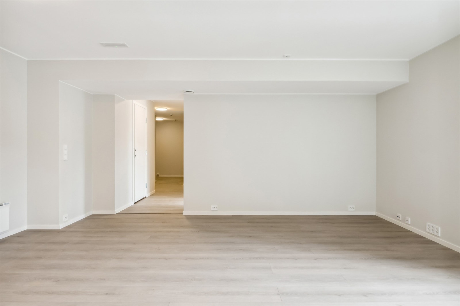 Lys og romslig stue med moderne, lyst laminatgulv og rene, nøytrale vegger. Perfekt for tilpasning etter eget ønske. Galleribilde