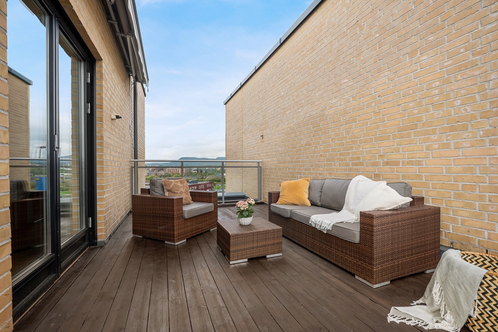 Terrassen har gulv av terrassebord, rekkverk i glass og metall, og er utstyrt med markise for solskjerming. Galleribilde