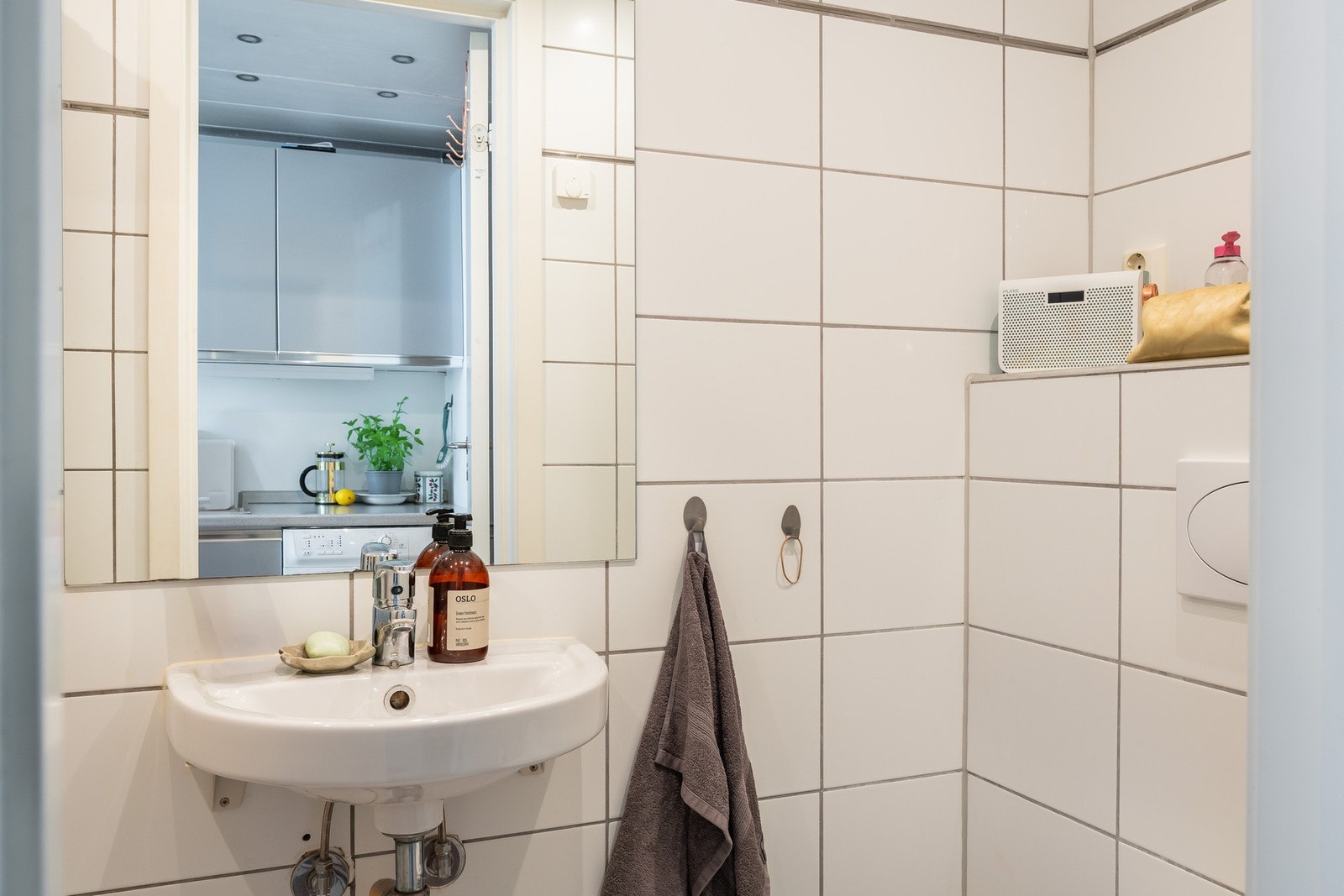 Flislagt bad med dusjnisje med dusjforheng, servant med ett greps blandebatteri og vegghengt toalett. Galleribilde