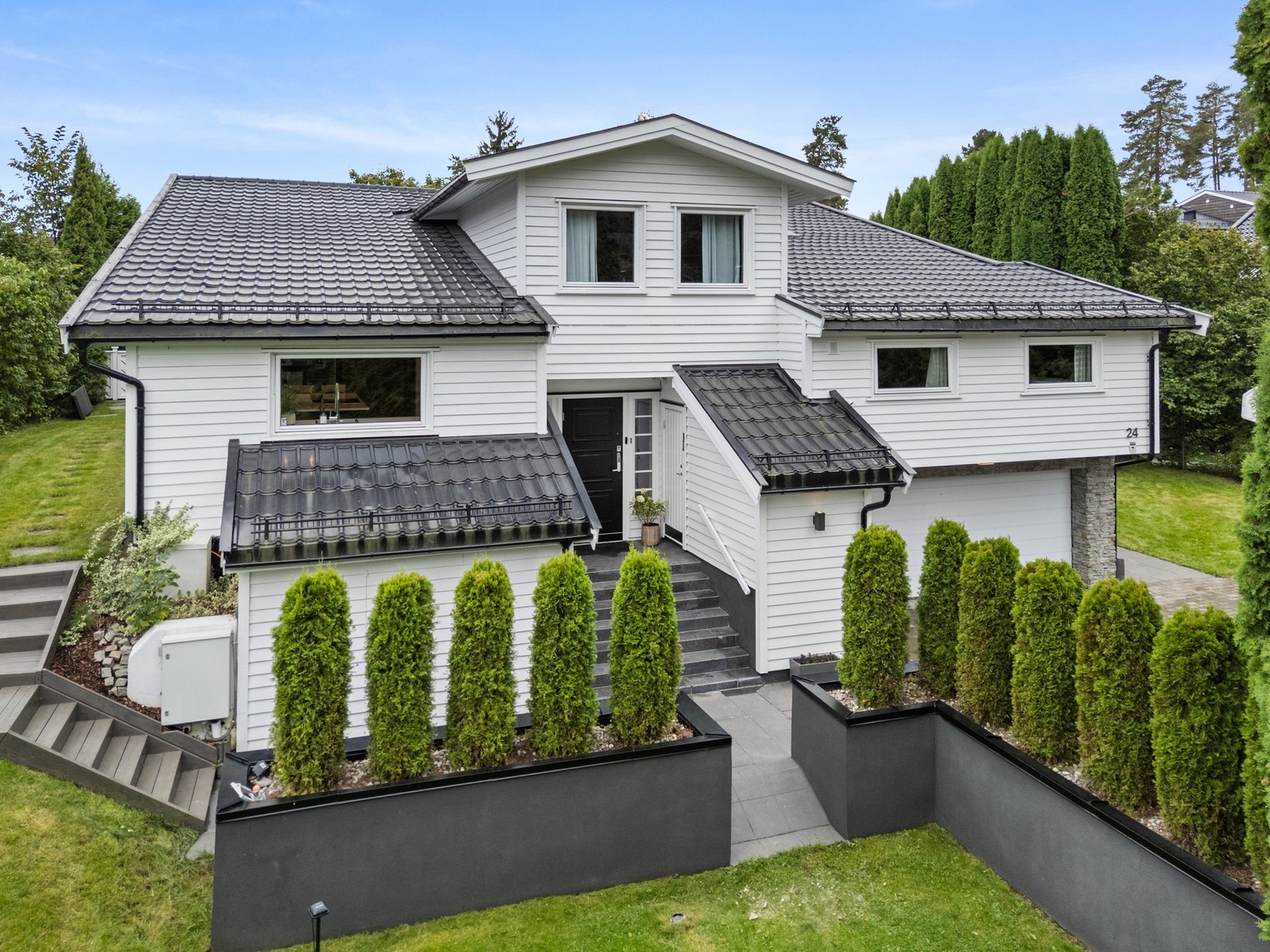 Eiendommen er pent opparbeidet med plen, variert beplantning, stor terrasse, belegningssteinlagt innkjørsel og frittstående byggverk. Galleribilde