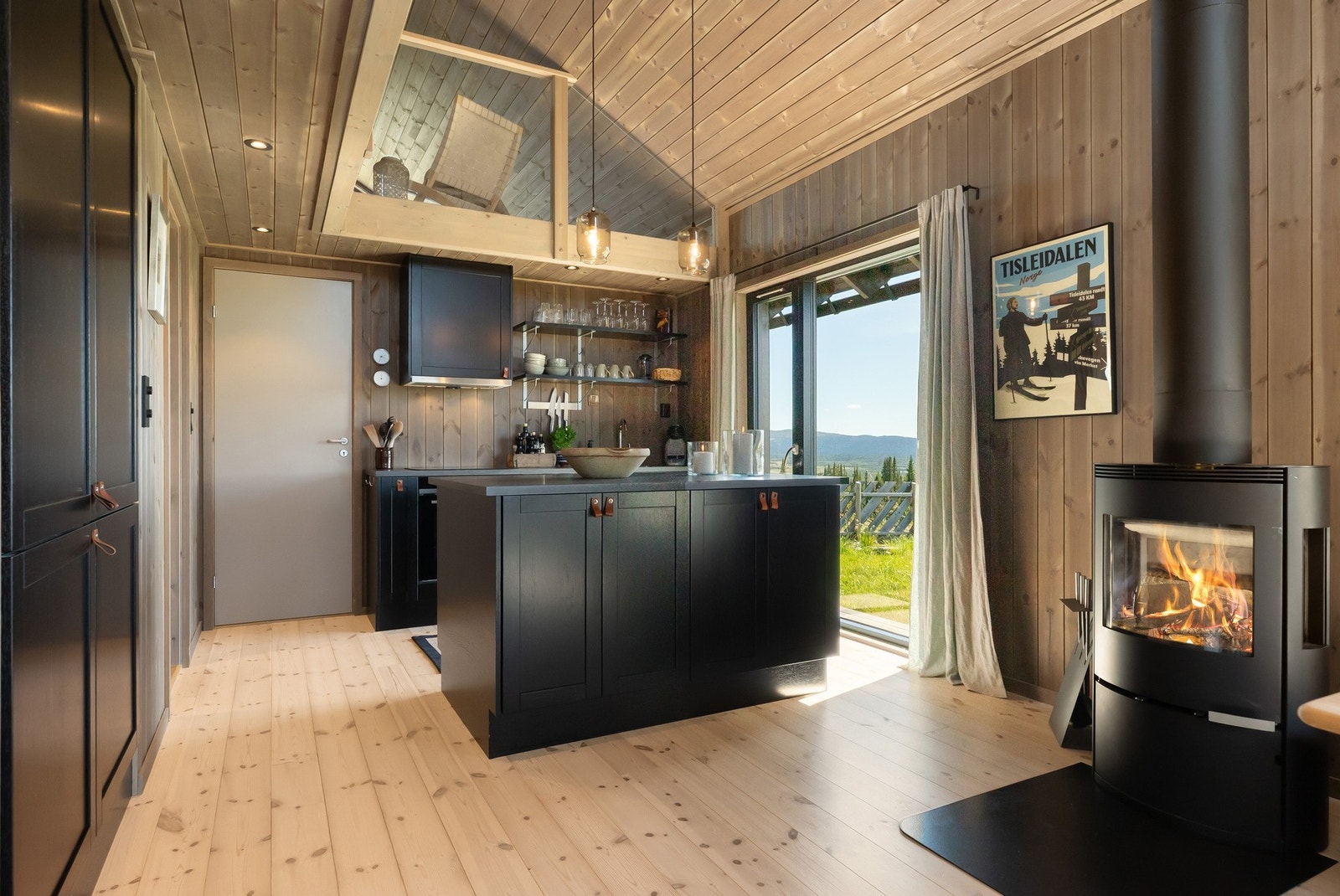 Kjøkkenet har en moderne og åpen løsning med stilren innredning fra Sigdal, i en elegant sort fargetone Galleribilde