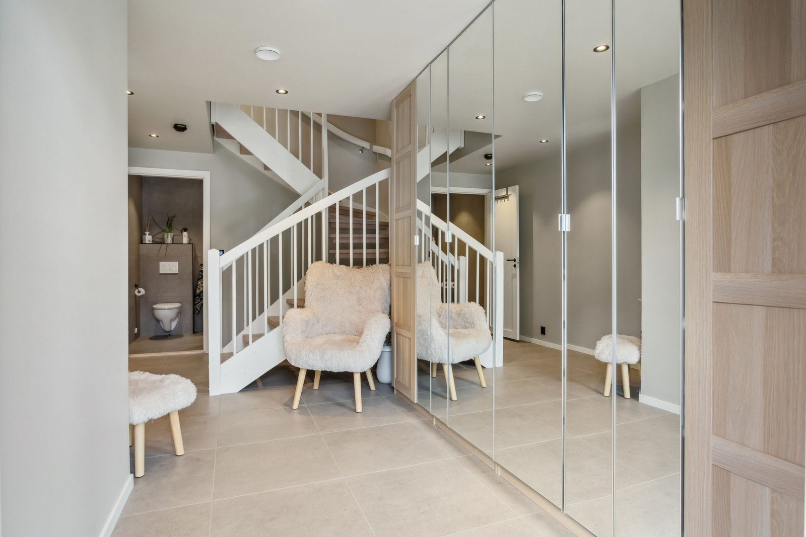 Hall med fliser på gulv og Ikea PAX garderobe løsning som følger med boligen Galleribilde