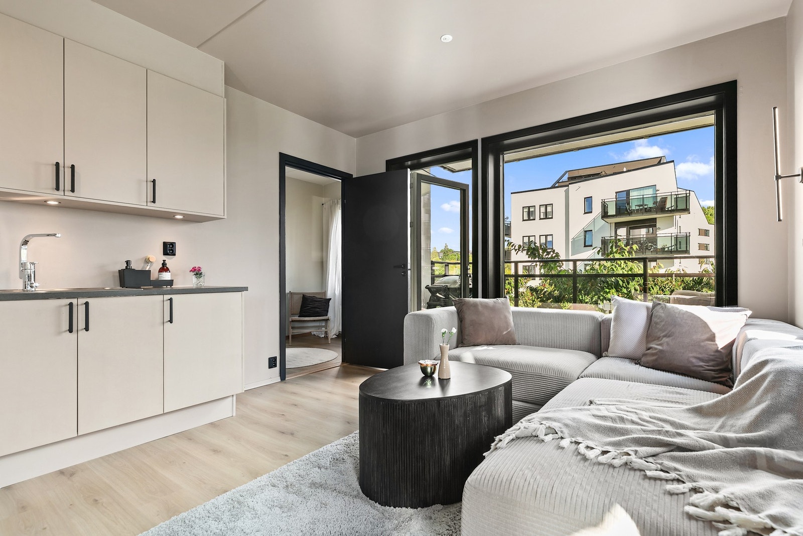 Kjøkken og stue gir tilgang til et av leilighetens to soverom. Galleribilde