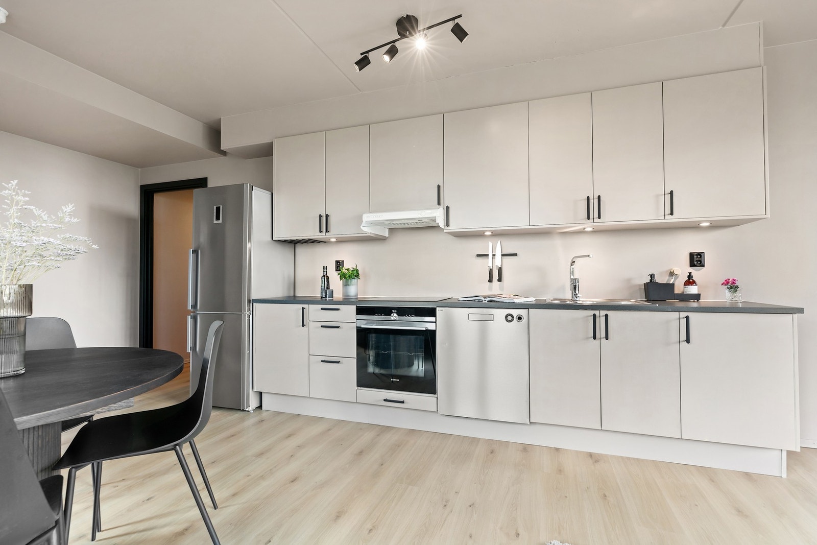 Her er løst plassert kjøleskap og integrerte hvitevarer som oppvaskmaskin, stekeovn og en platetopp. Galleribilde